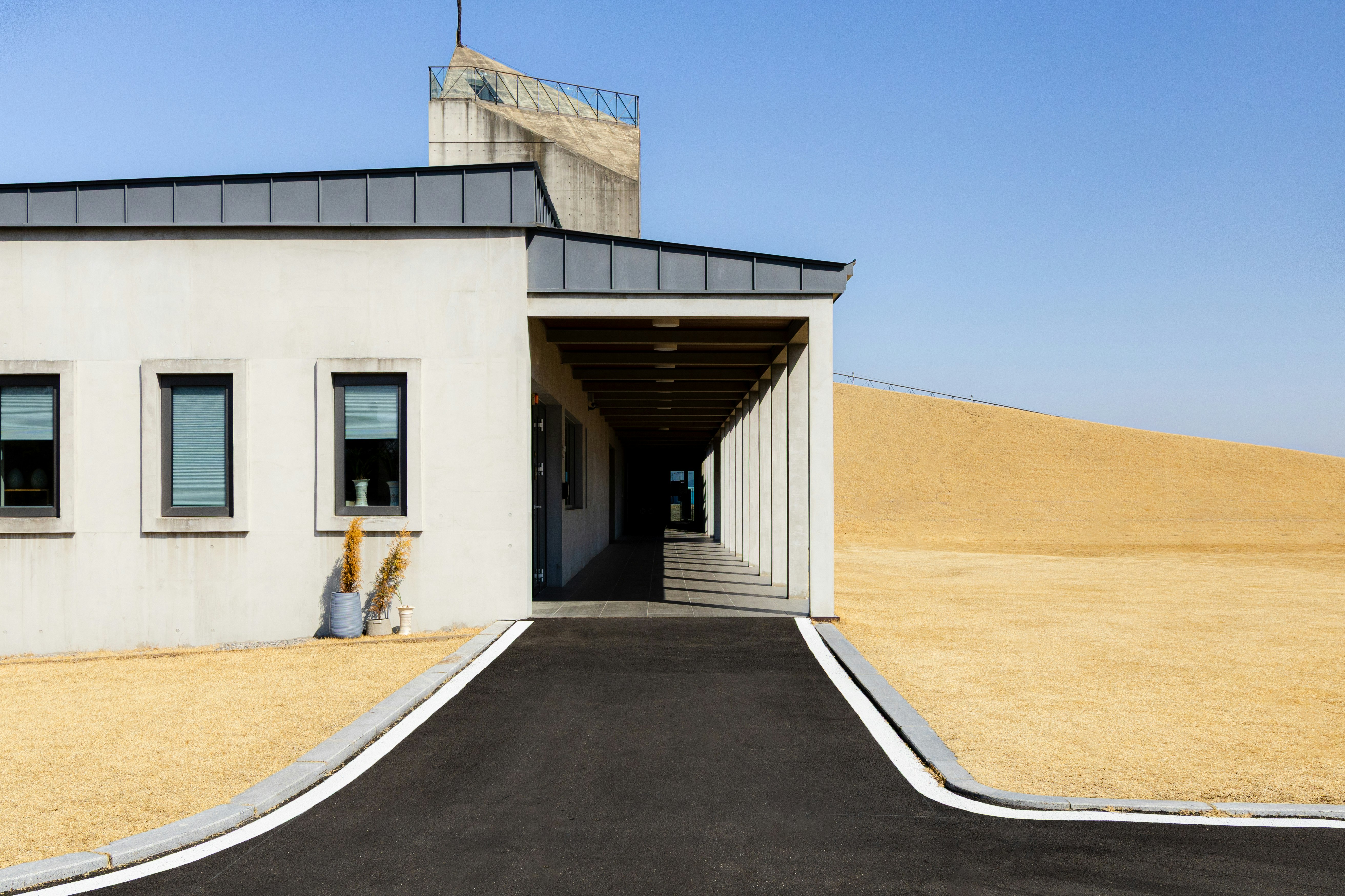 白い建物と中庭の直線的な通路のある建築外観