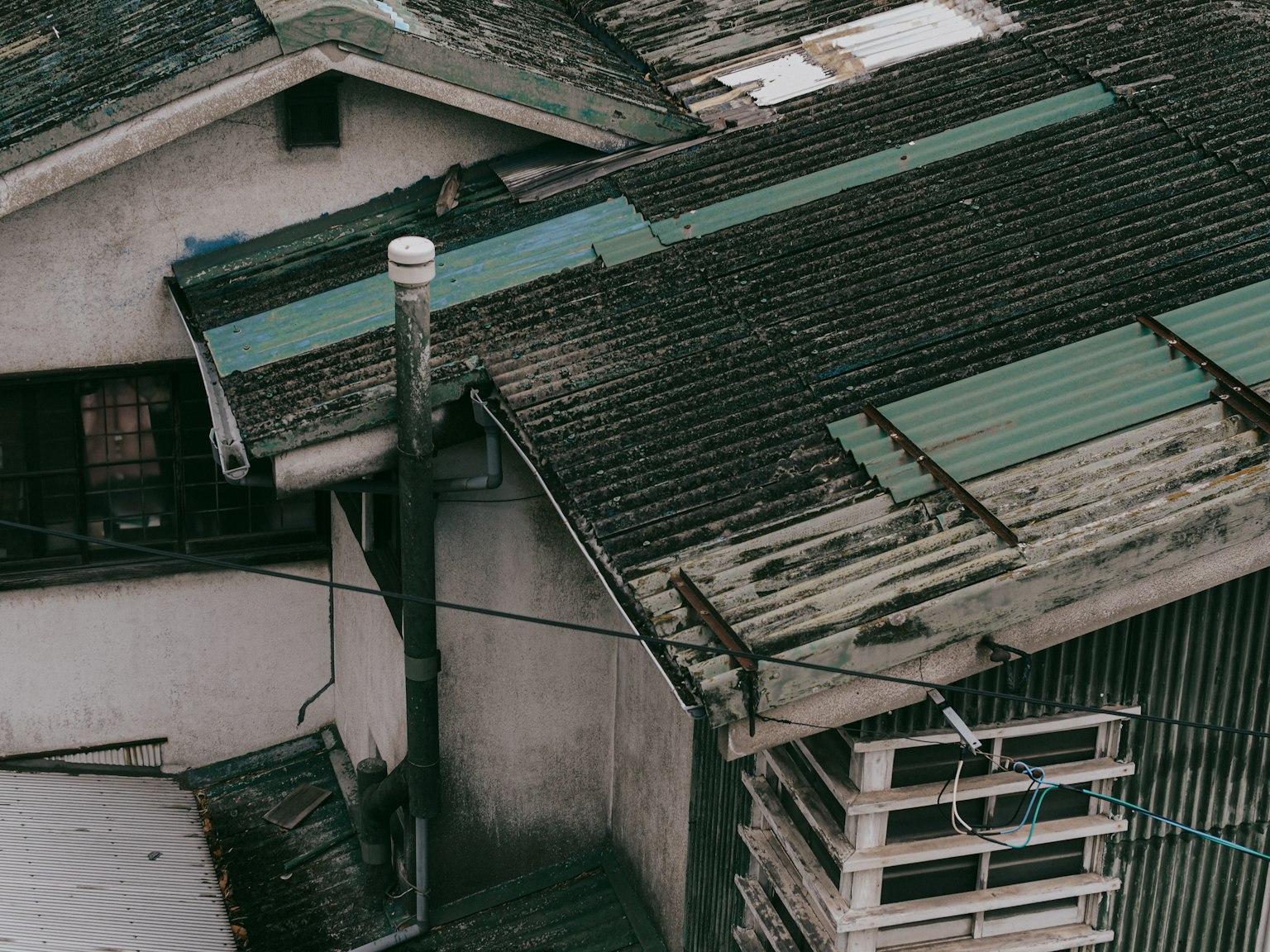 Atap rumah tua dengan struktur atap logam hijau dan kayu