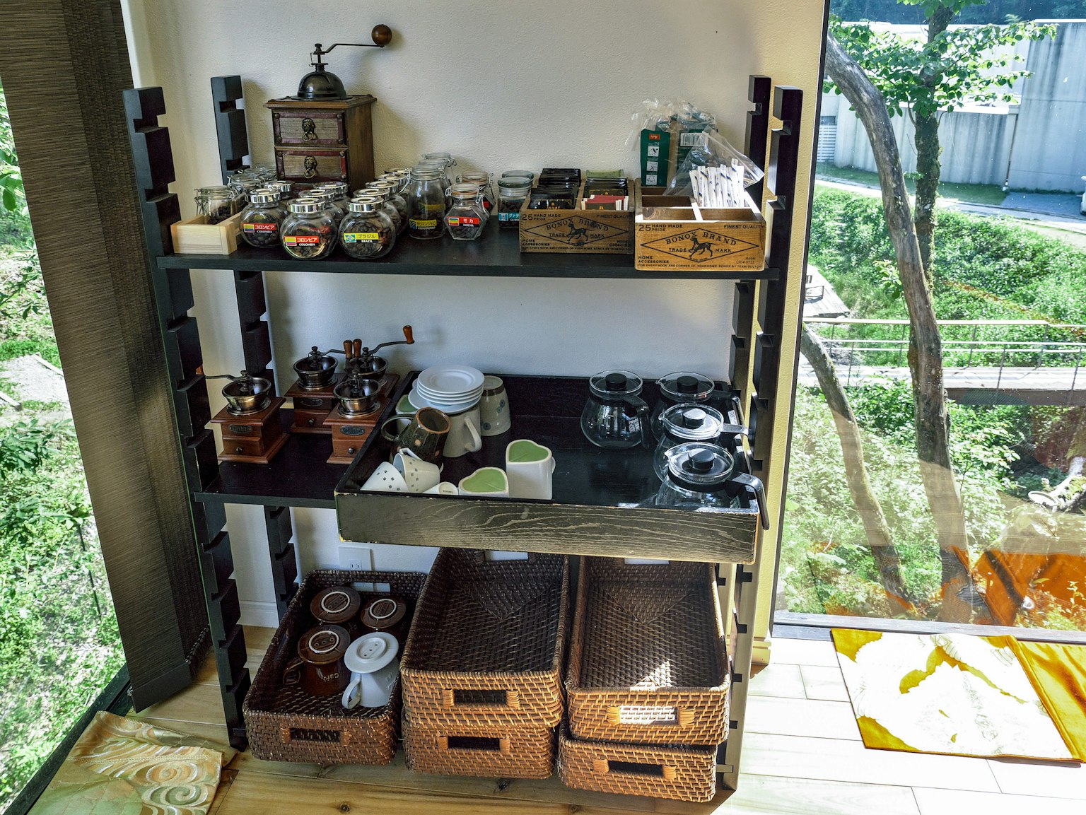 Un rincón de una habitación que muestra varios utensilios de té y platos dispuestos en una estantería