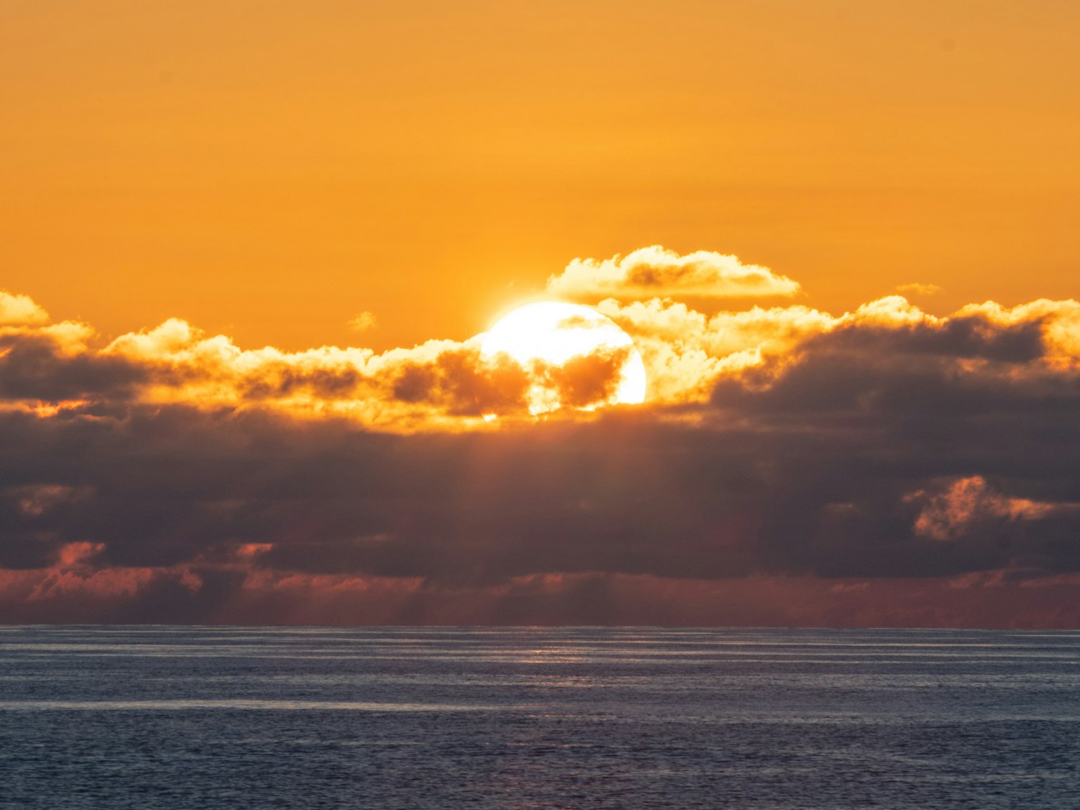 Bellissimo paesaggio marino con il sole che sorge tra le nuvole