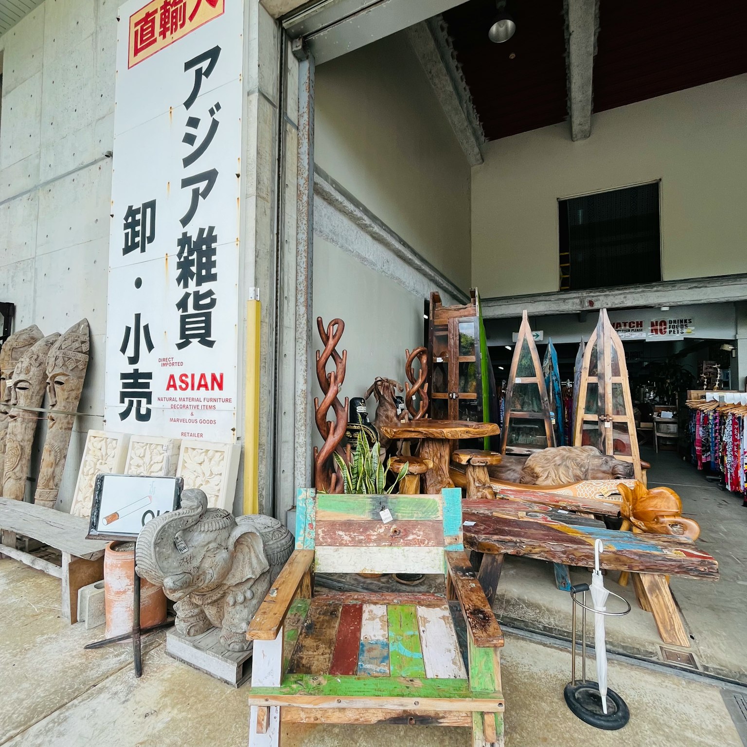 Exterior de una tienda de productos asiáticos con sillas de madera y artículos decorativos