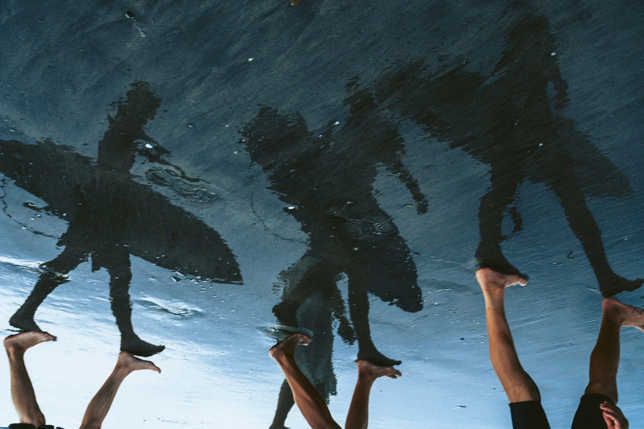people holding surfboards in the splashing waves