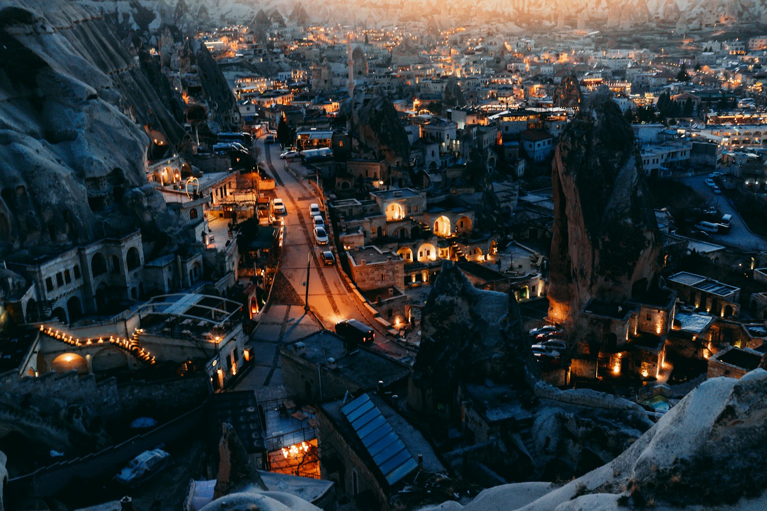Vista notturna di Cappadocia con formazioni rocciose uniche e case illuminate