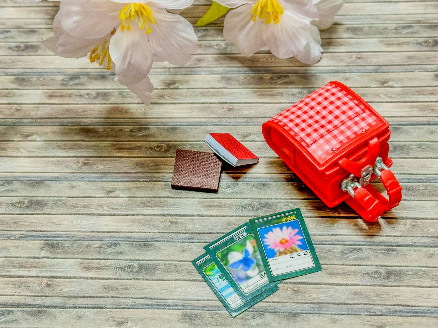 Một chiếc túi đỏ với thẻ và hoa được sắp xếp trên bề mặt gỗ