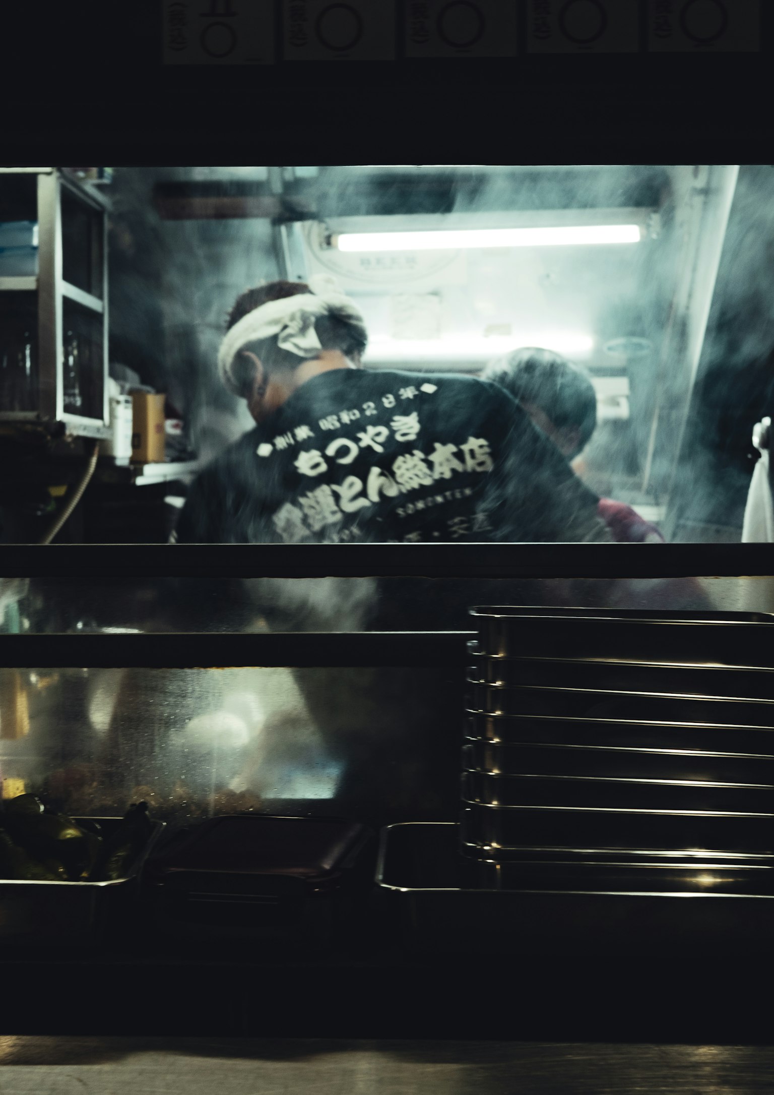 Chef working in a food stall surrounded by steam