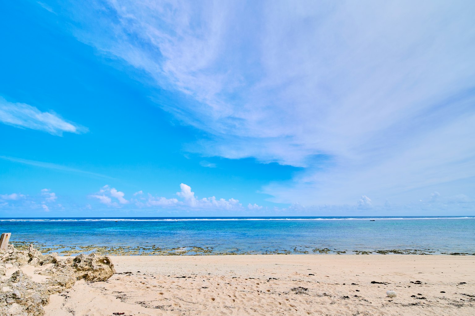 Pemandangan pantai dengan langit biru cerah dan lautan jernih
