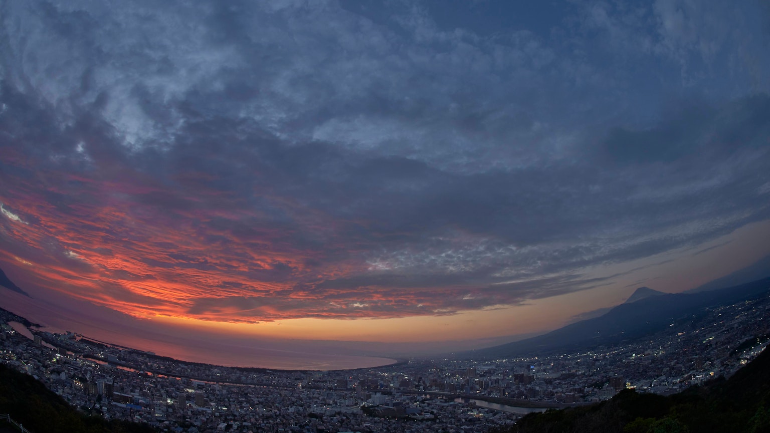 Panoramic view of a cityscape at sunset with vibrant colors