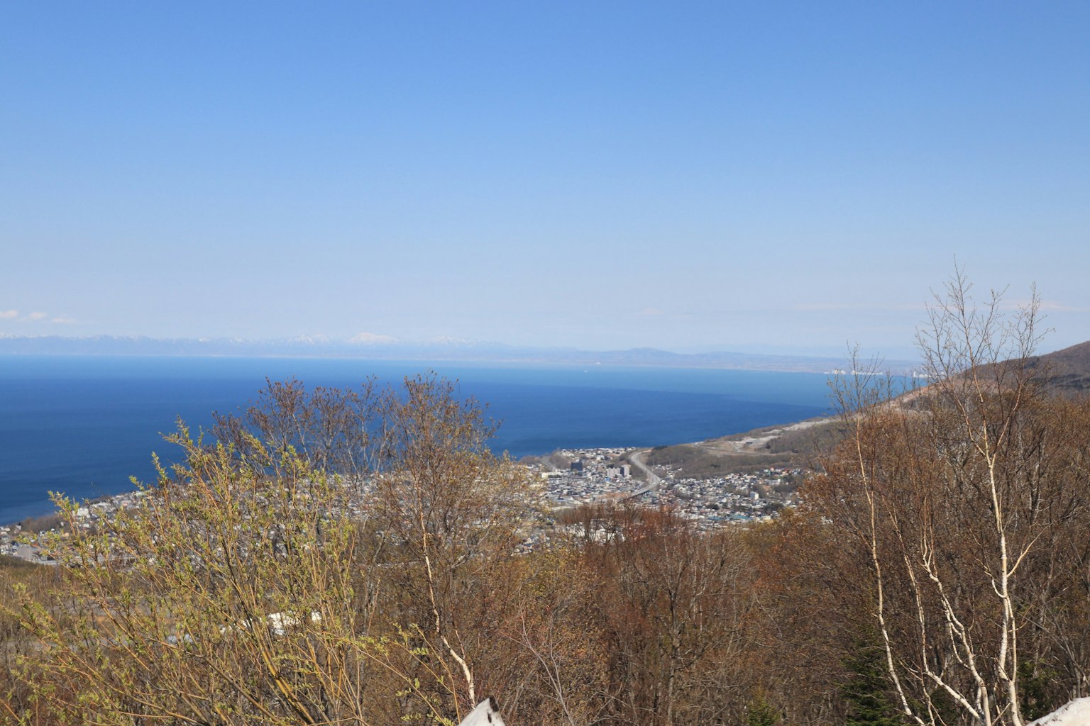 Vista panoramica dell'oceano blu e del cielo con montagne e una città