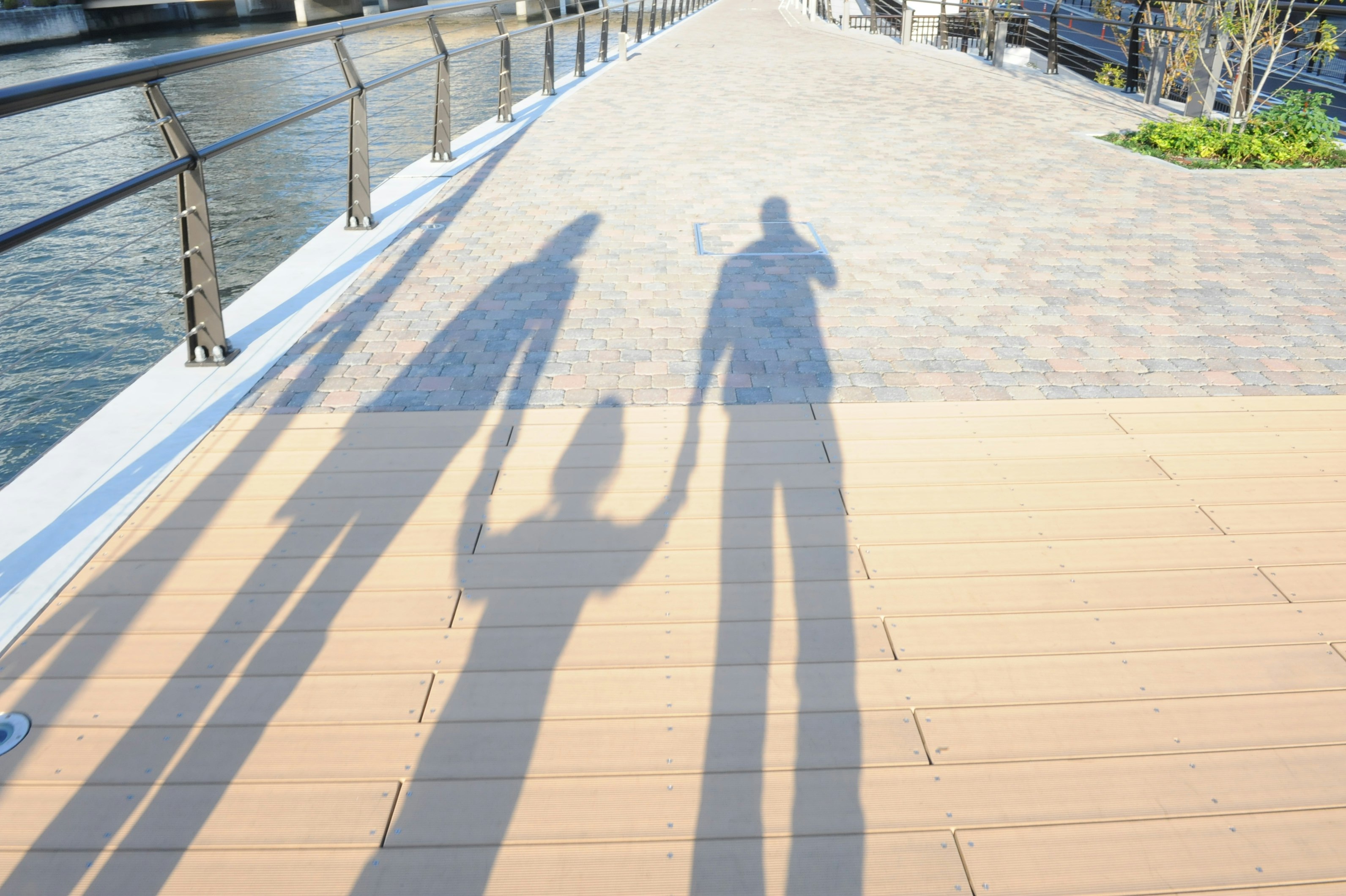 silhouette seseorang berjalan di sepanjang promenade tepi sungai