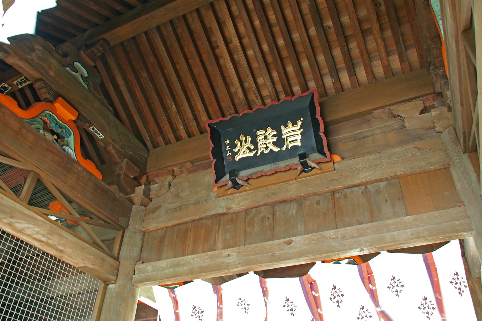 Panneau en bois et éléments décoratifs sous un toit architectural japonais traditionnel