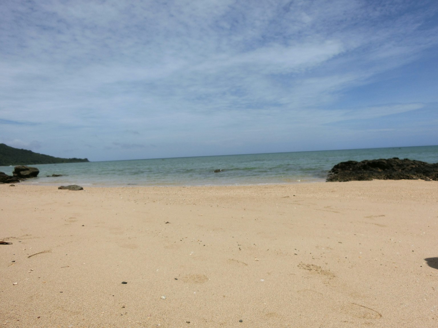 Scena di spiaggia tranquilla con mare calmo e cielo blu