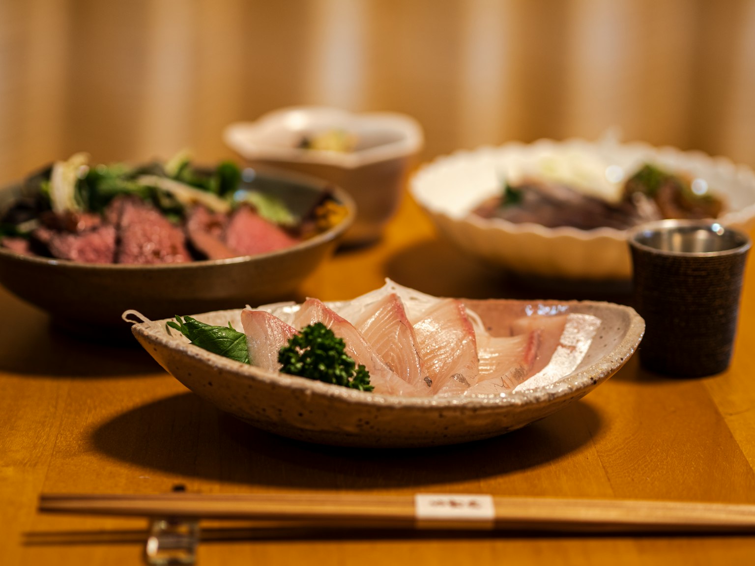 Bellissima disposizione di un pasto giapponese con sashimi fresco e piatti di carne alla griglia