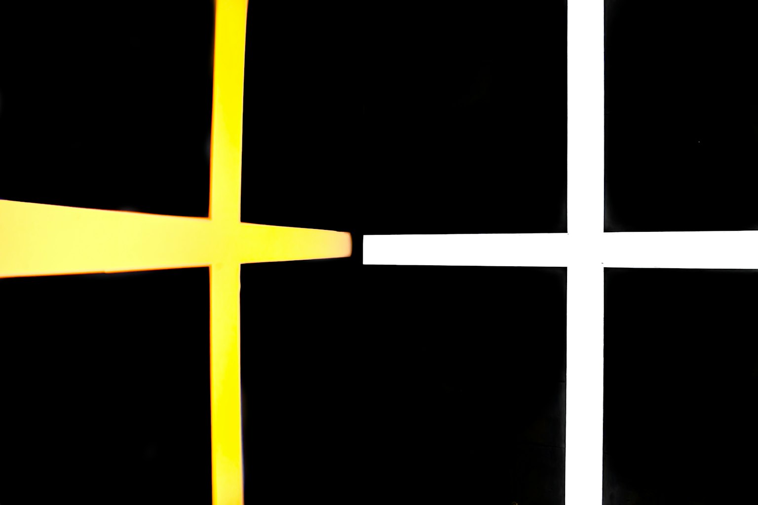 Design semplice con croci gialle e bianche che si incrociano su uno sfondo nero