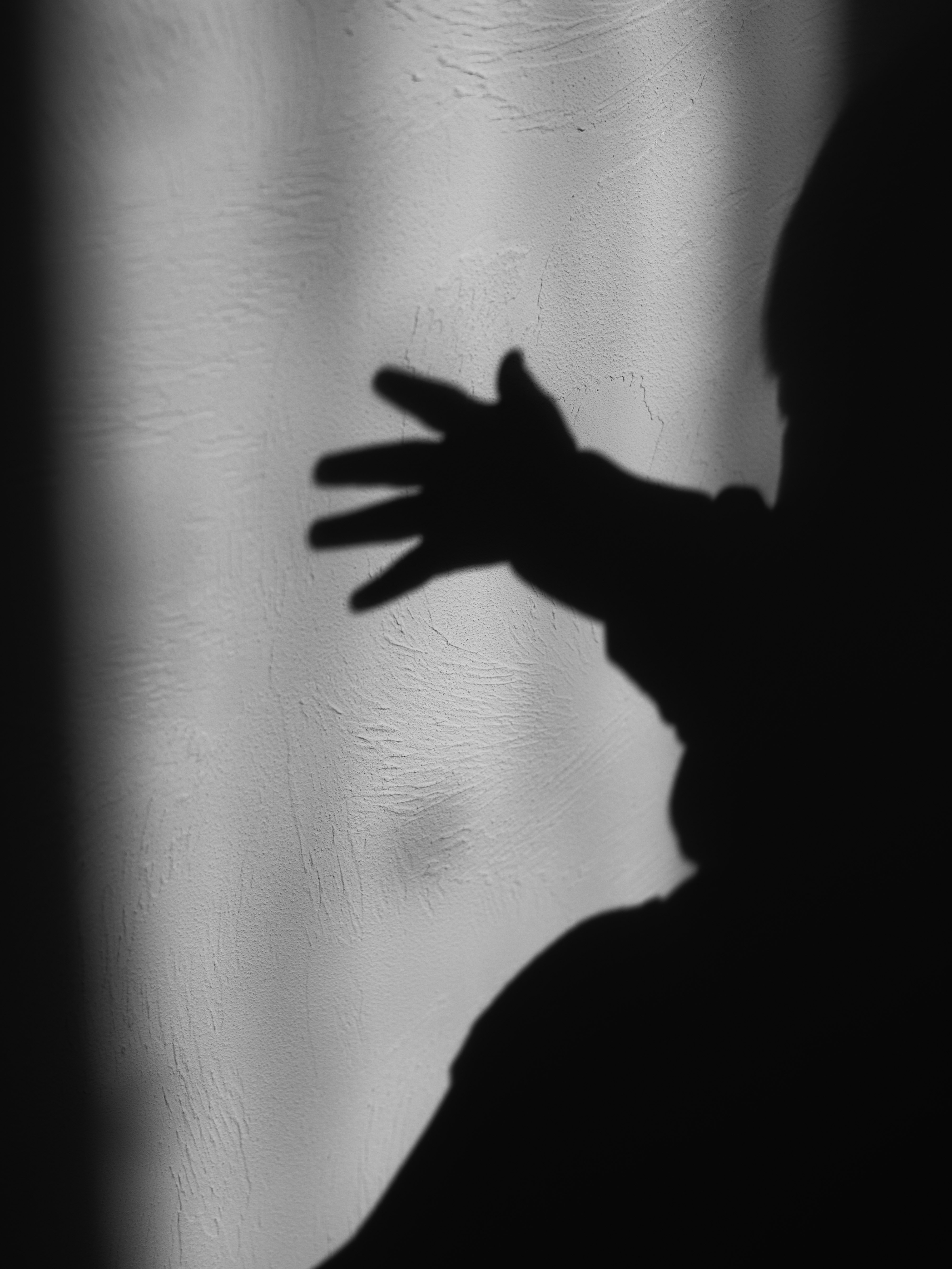 morning light with a hand silhouette overlapping wall shadows