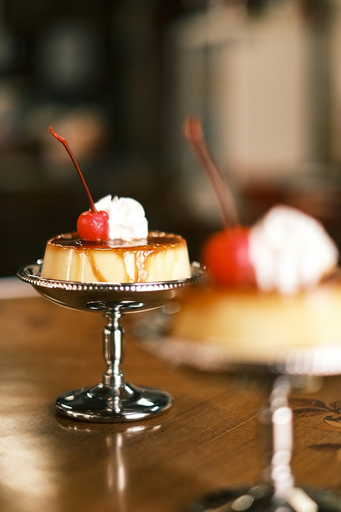昔ながらのプリンとスプーンのあるカフェのテーブル