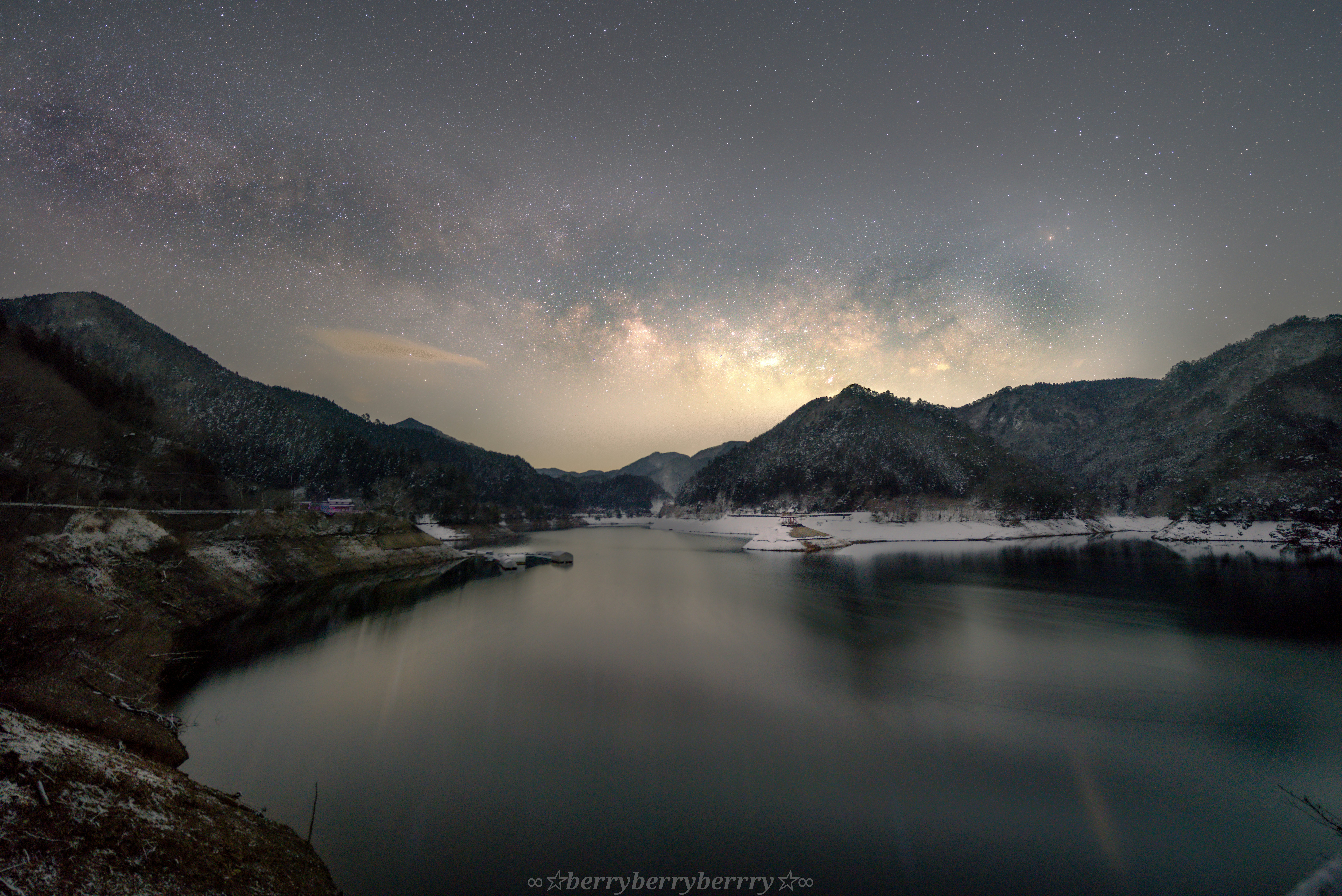 山あいの湖に広がる天の川の夜景