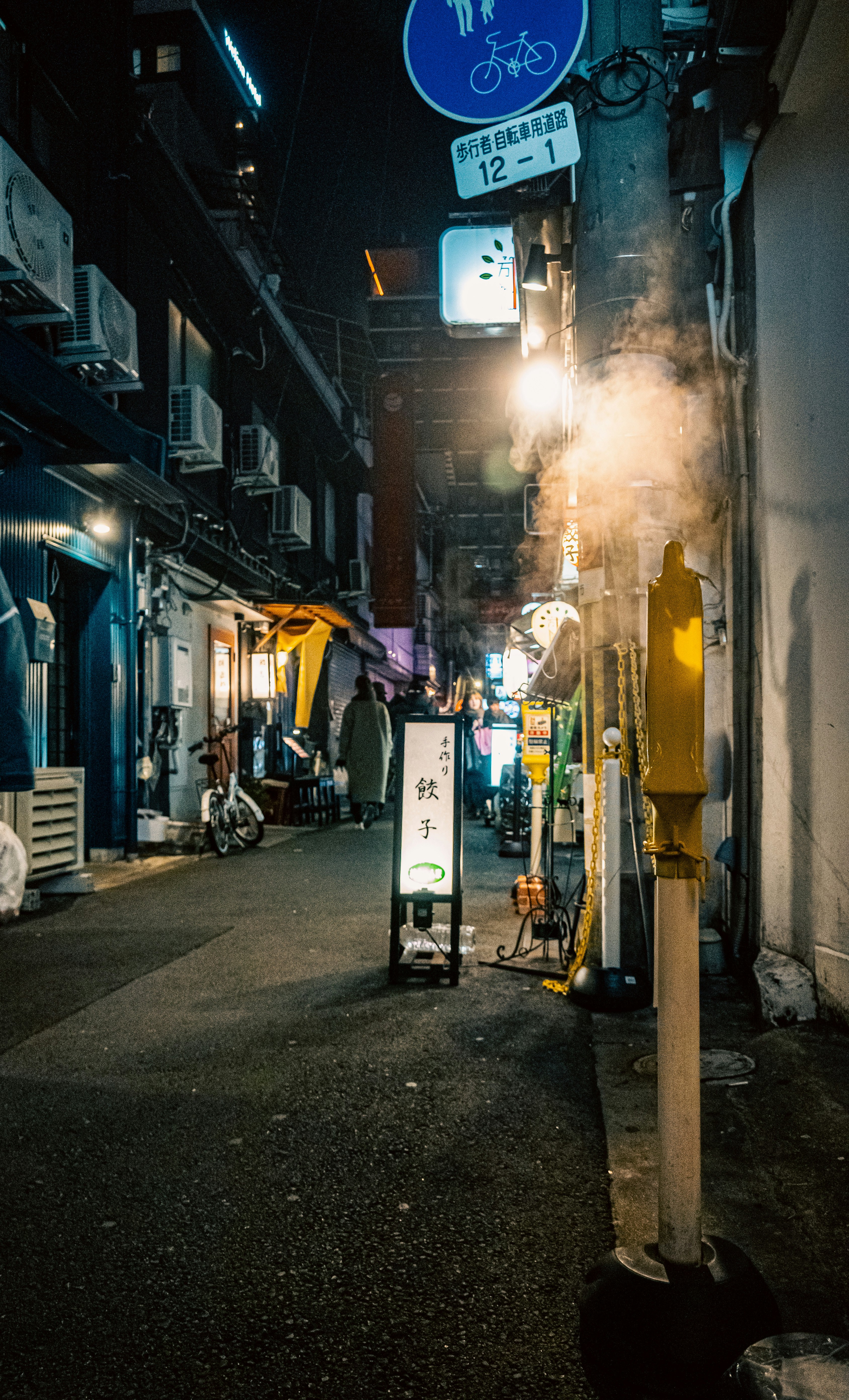 nächtliche Gasse mit Schildern in einer Einkaufsstraße