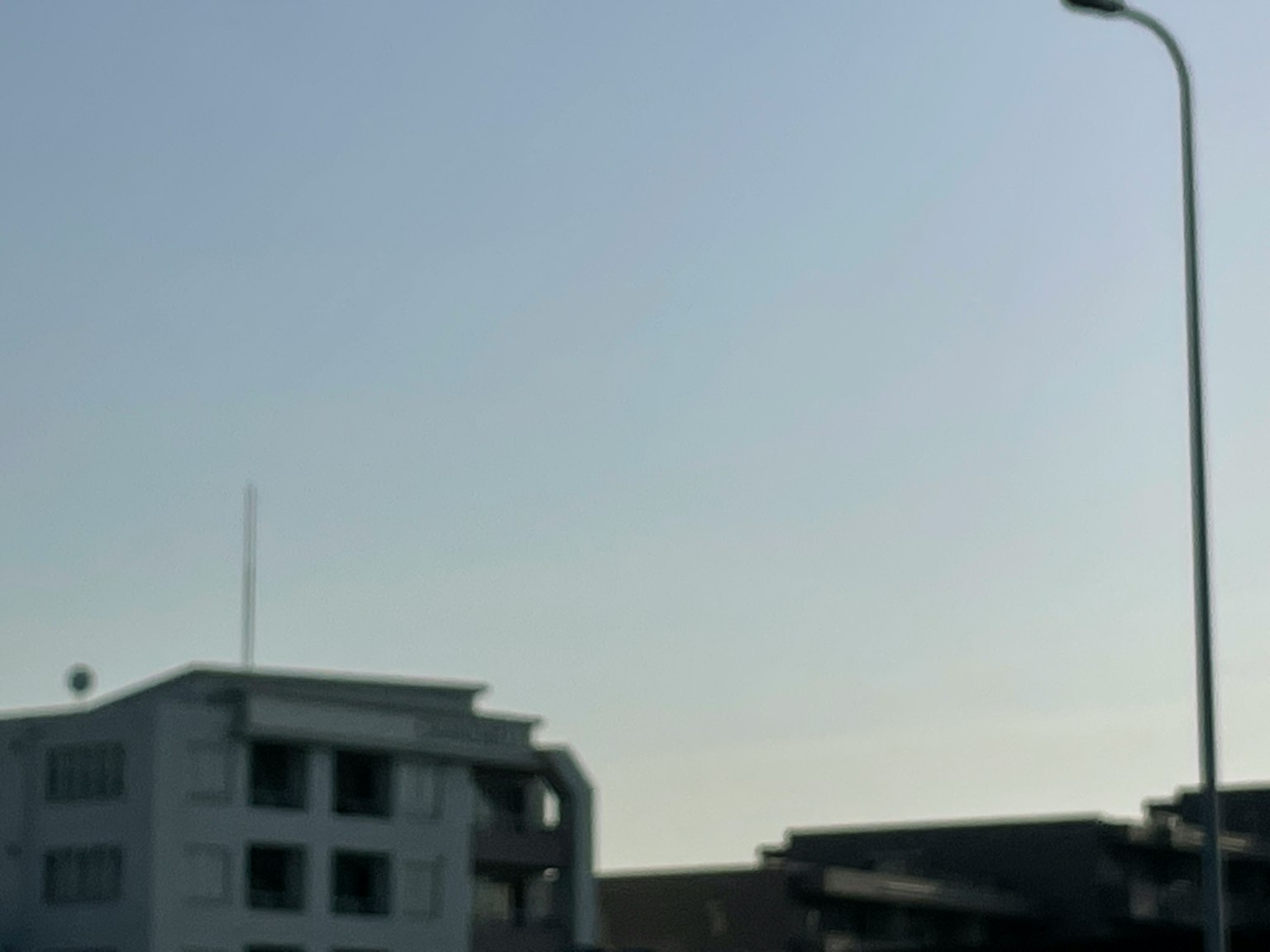 푸른 하늘 아래 현대적인 건물과 가로등