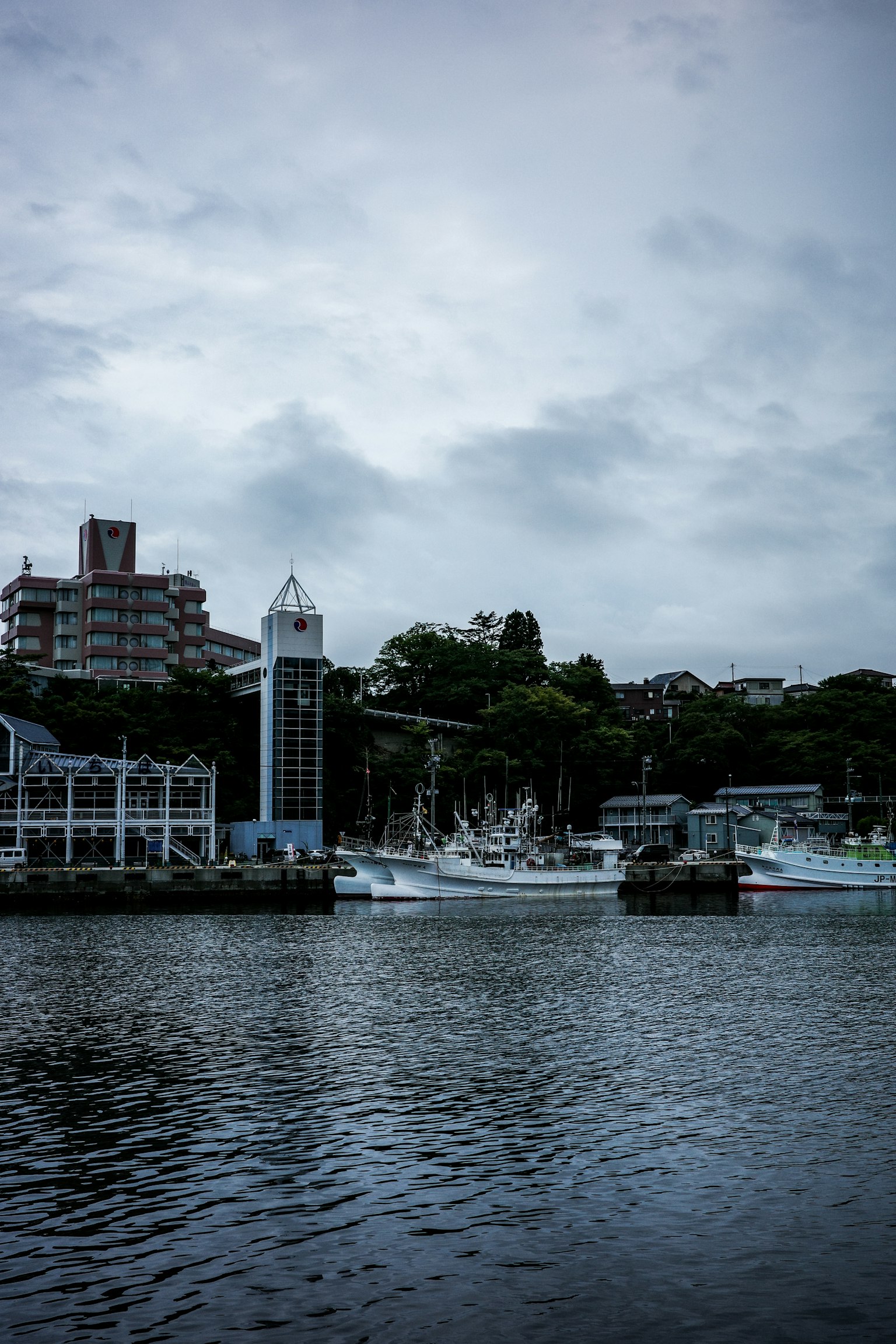 ทิวทัศน์ท่าเรือที่เงียบสงบมีเรือและท้องฟ้าที่มีเมฆมาก