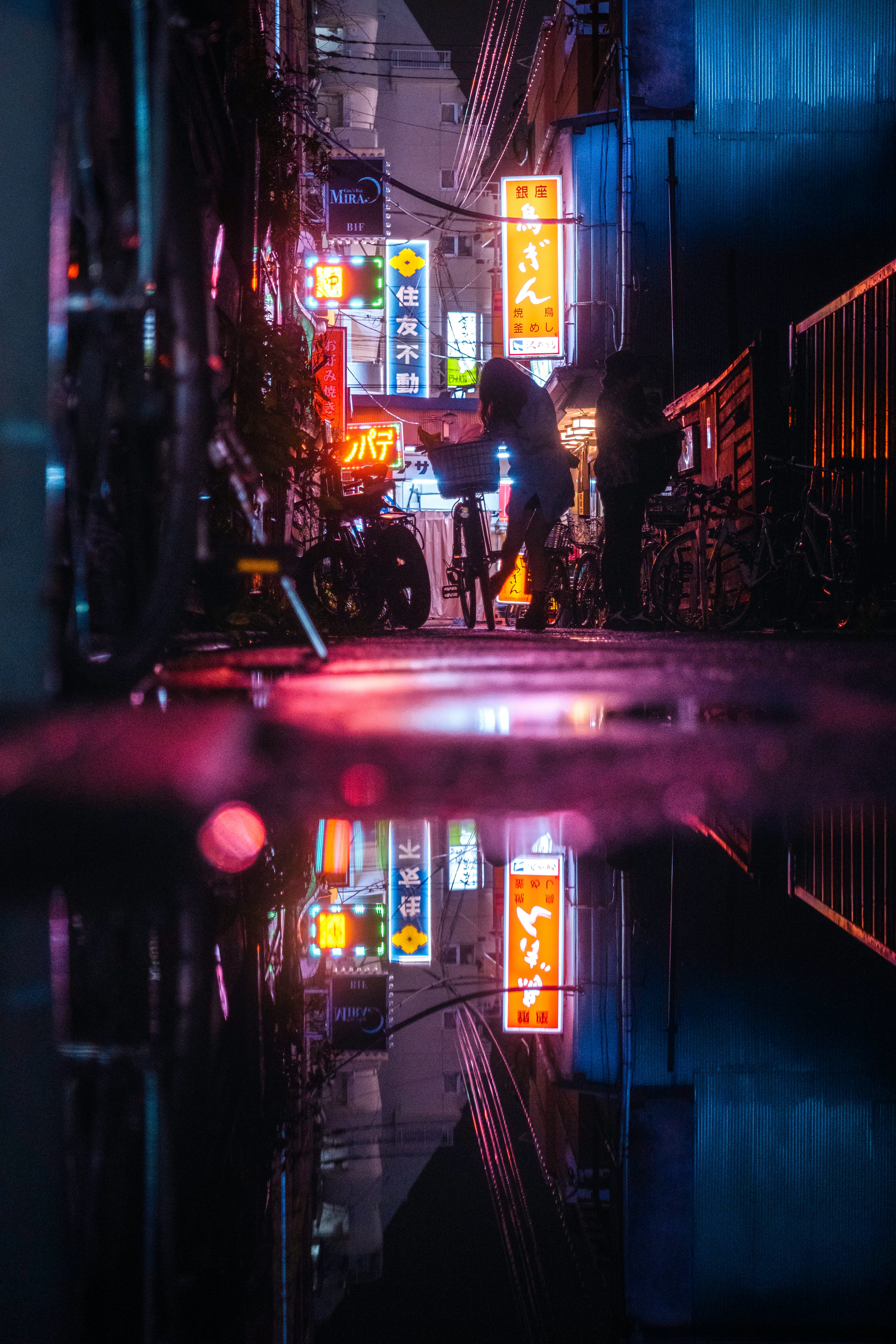 ネオン看板が並ぶ夜の路地の反射