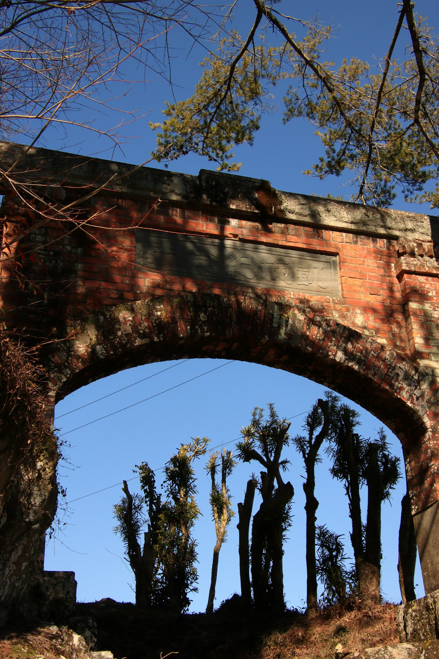 Silhouette di un vecchio ponte ad arco contro un cielo blu