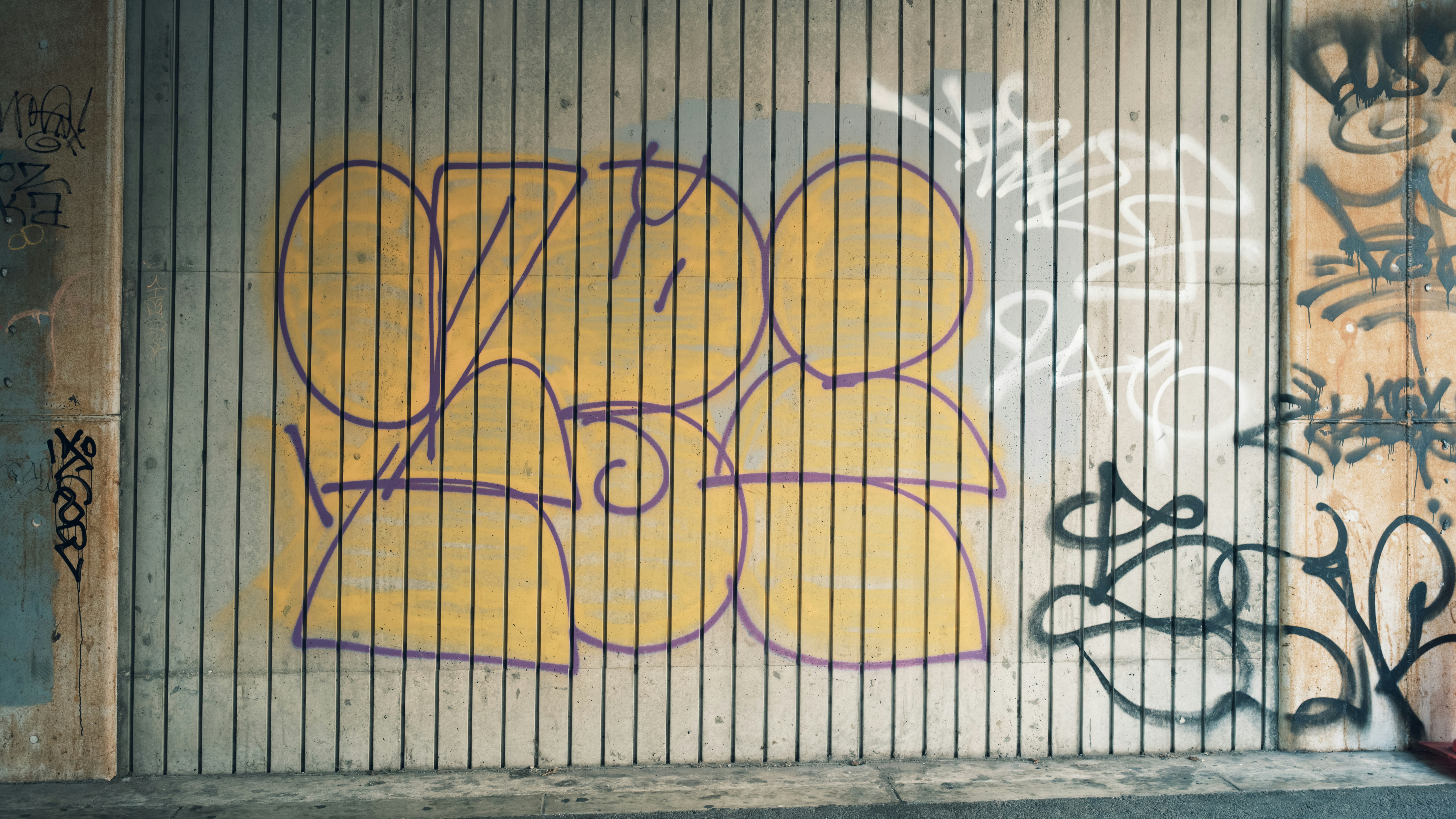 dinding penuh grafiti dengan bilah vertikal di gang