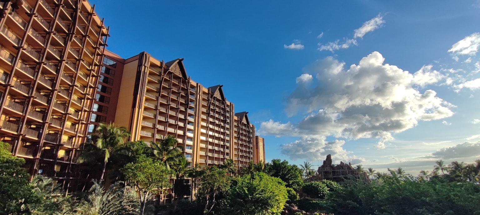 Vue extérieure d'un grand hôtel sous un ciel bleu avec de la verdure