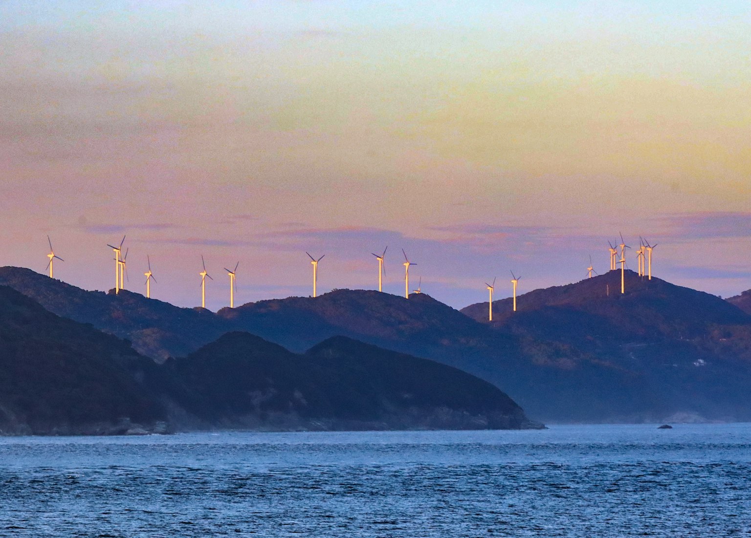 Landscape of mountains with wind turbines overlooking the sea