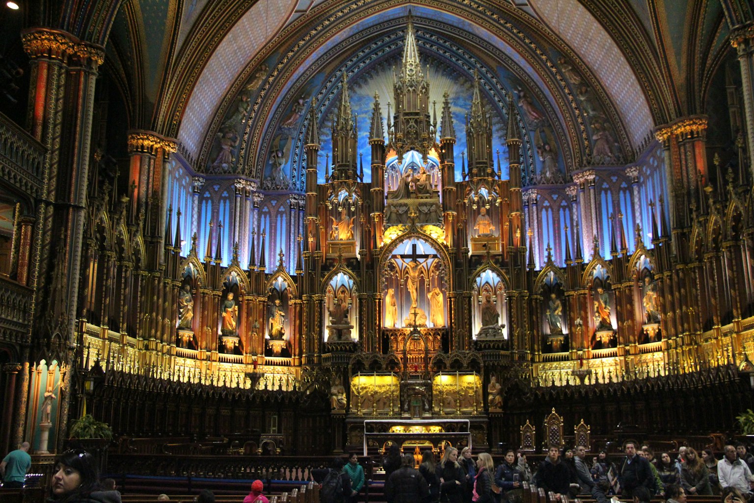 Interior de la basílica de Notre-Dame con un impresionante techo abovedado iluminación colorida y reunión de fieles
