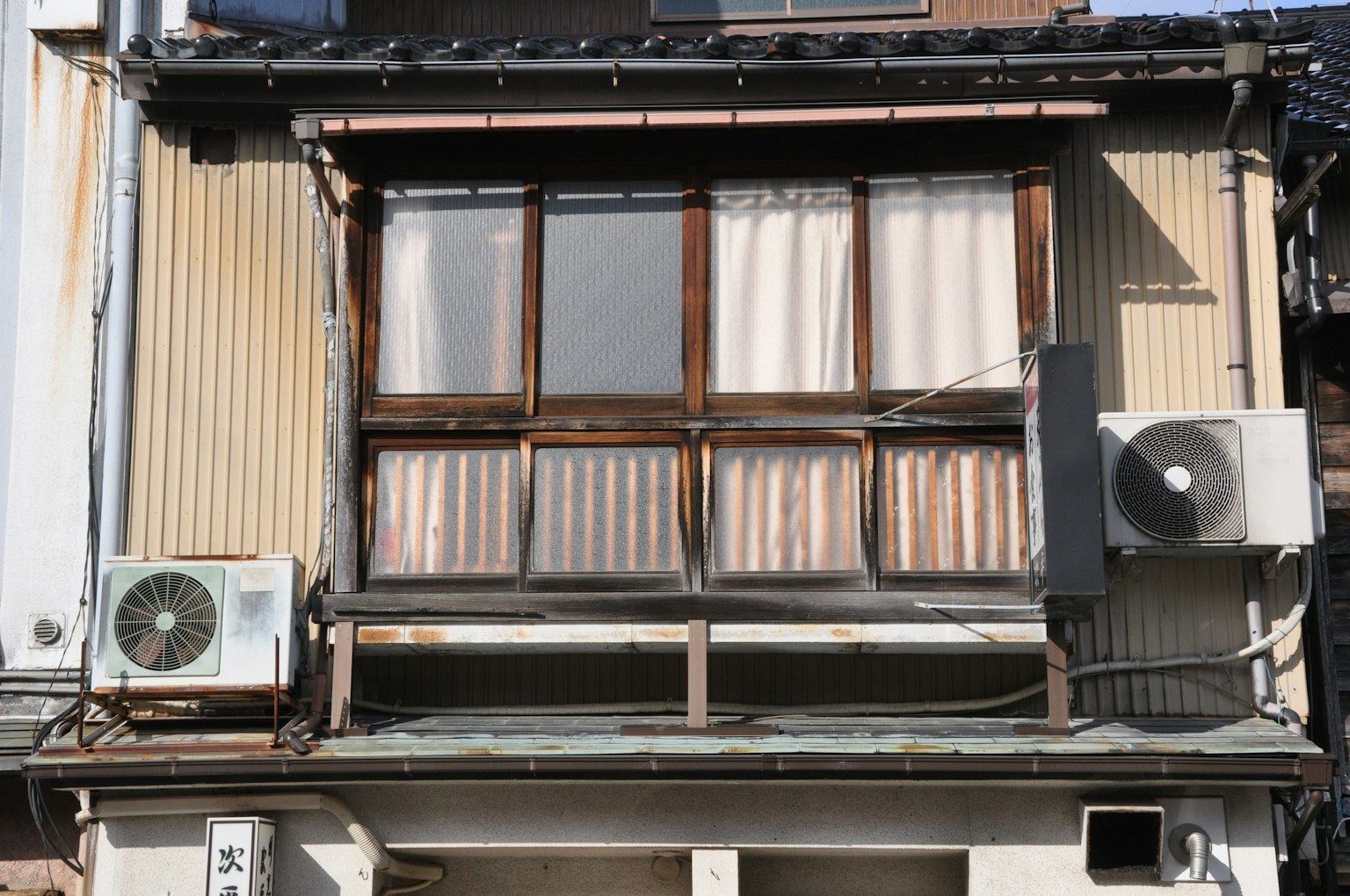 古い日本の家の窓とエアコンが特徴の外観