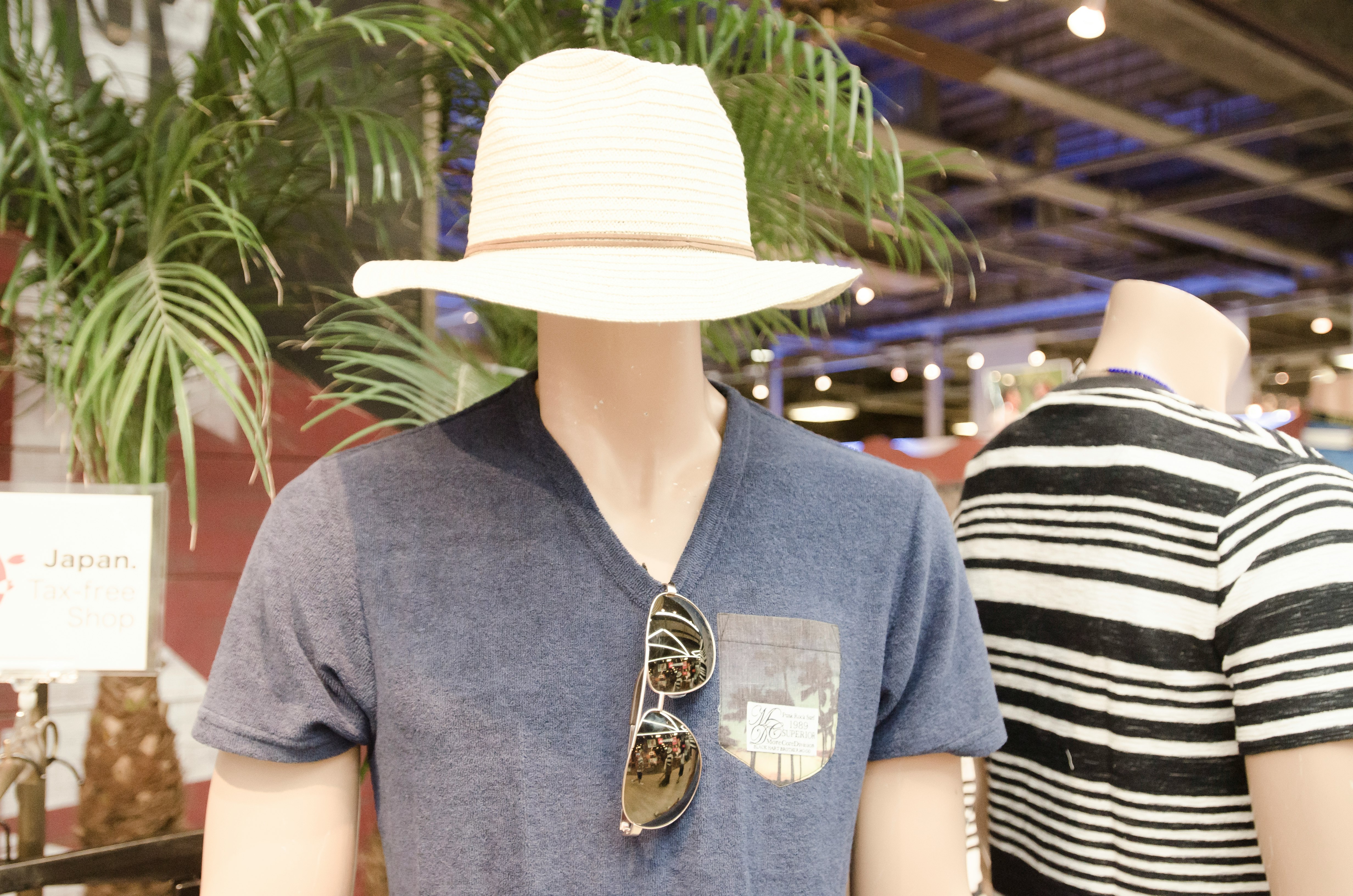 店内戴帽子的模特人偶与条纹服装人偶并排