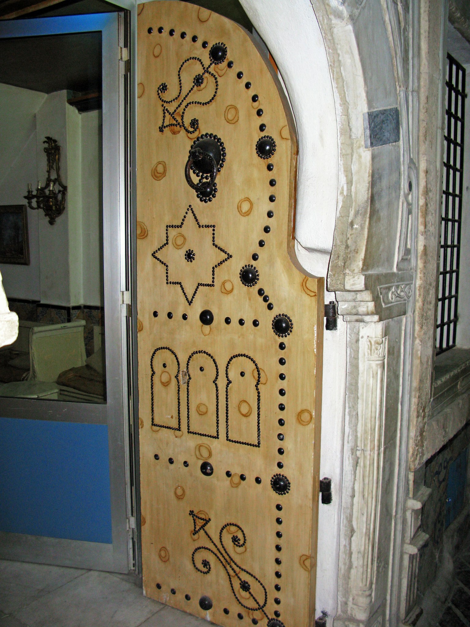 Puerta de madera decorativa con un diseño único y perillas ornamentales negras