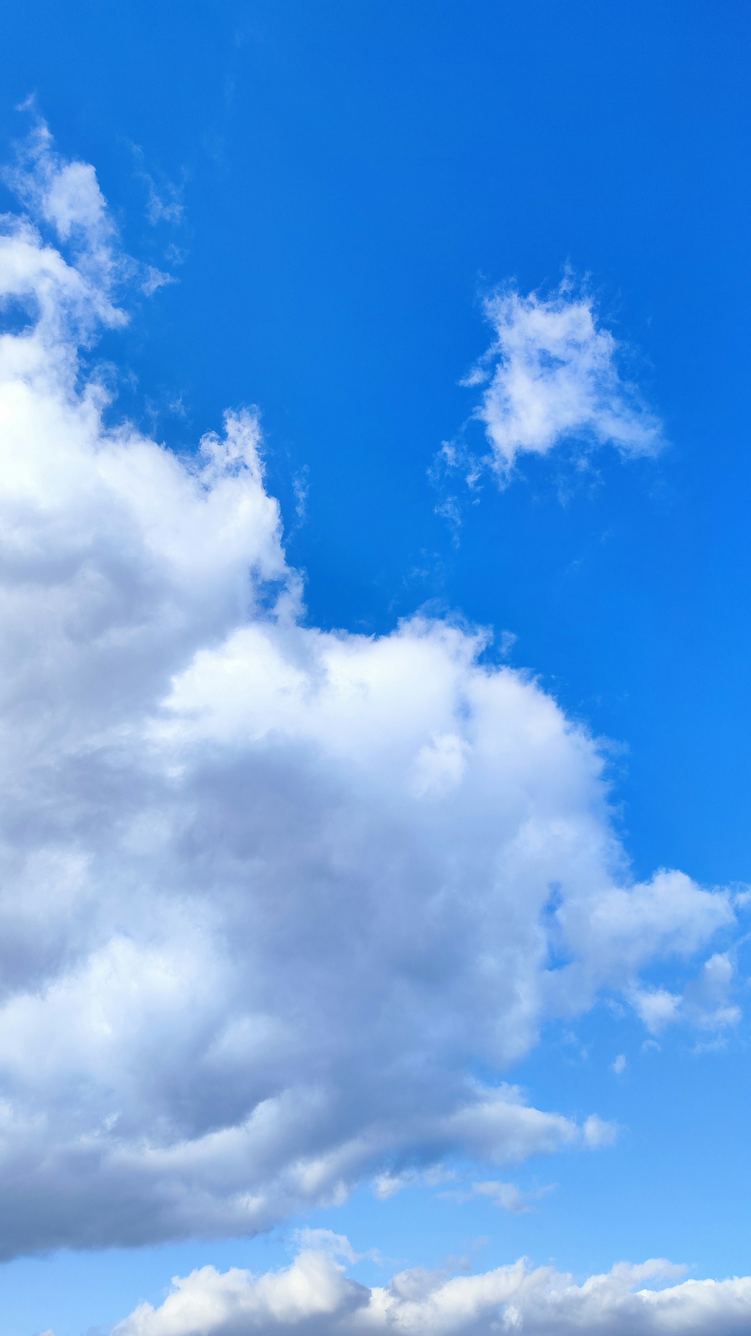 A clear blue sky with fluffy white clouds
