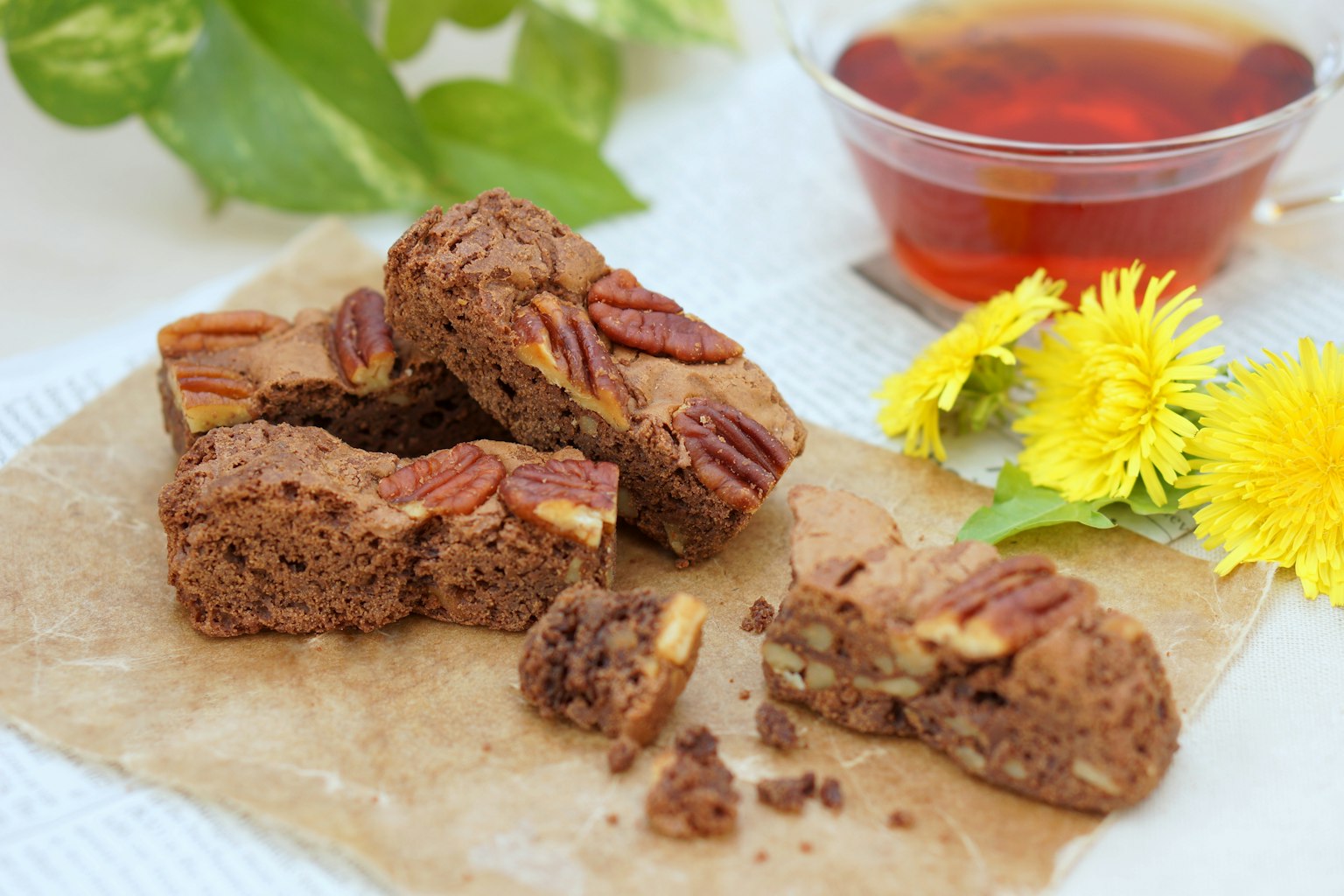 Brownies cokelat lezat dengan pecan disajikan dengan teh dan bunga