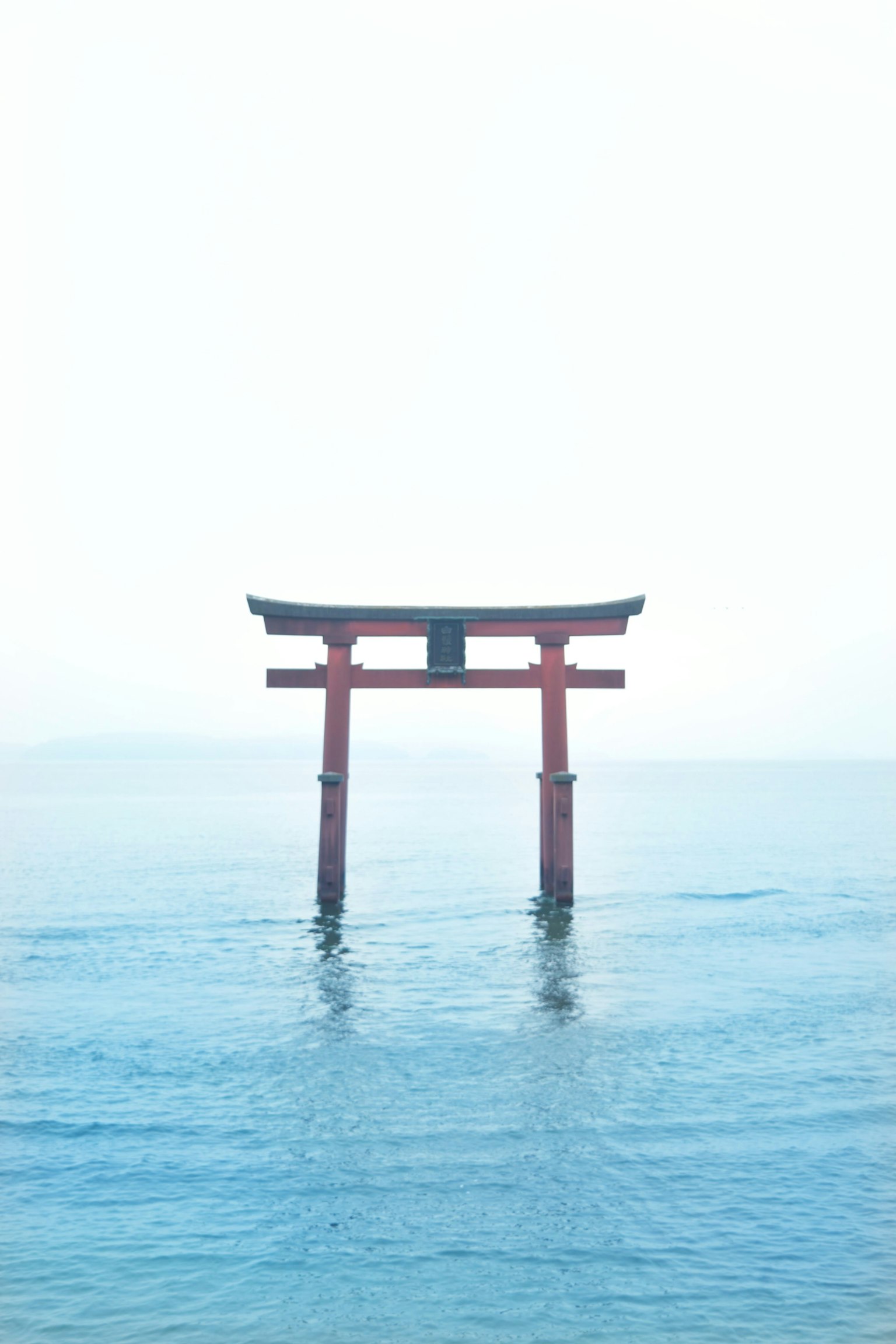 在海中屹立的鸟居蓝色水面和明亮的天空