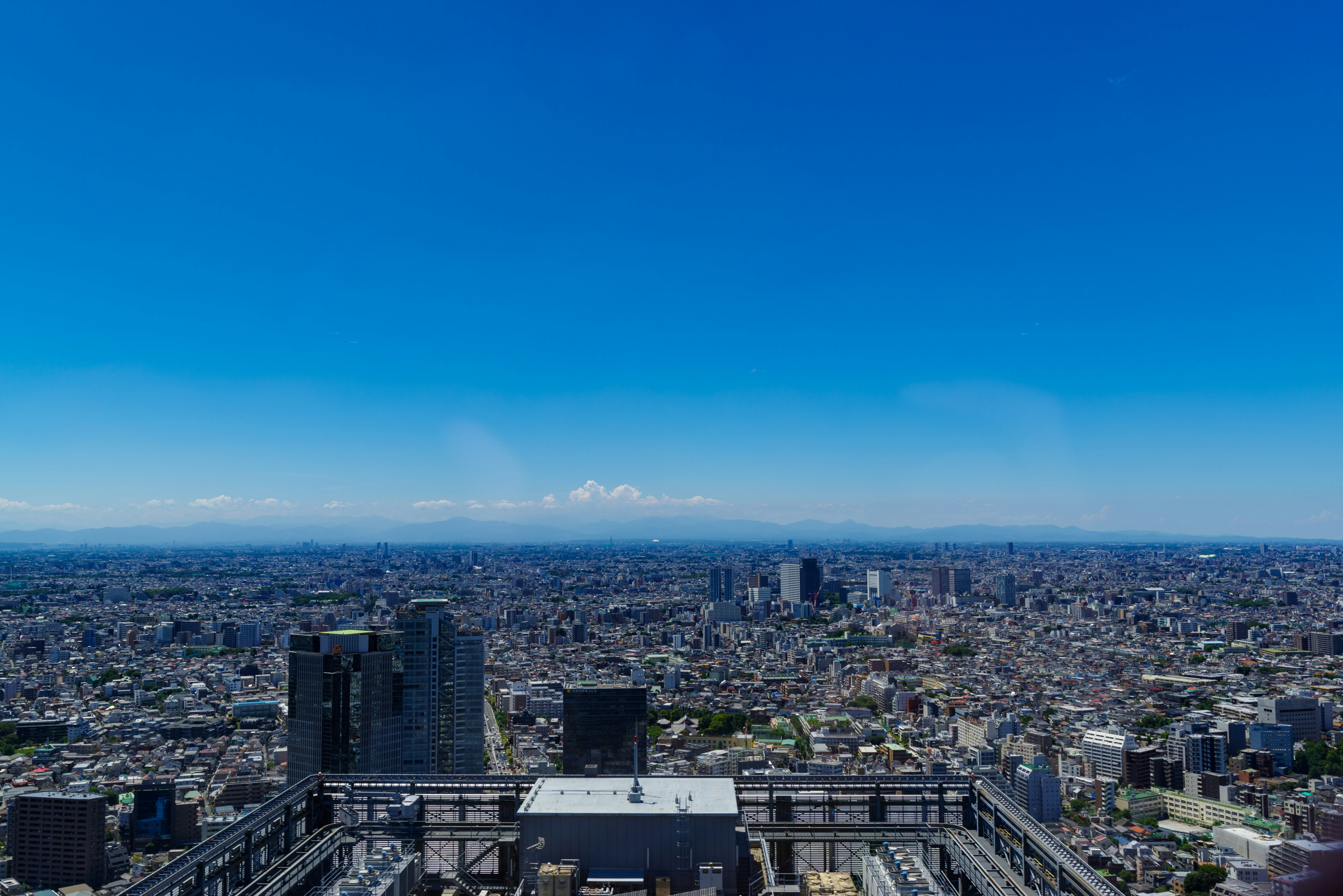 高層ビル群を見下ろす都市のパノラマと青空