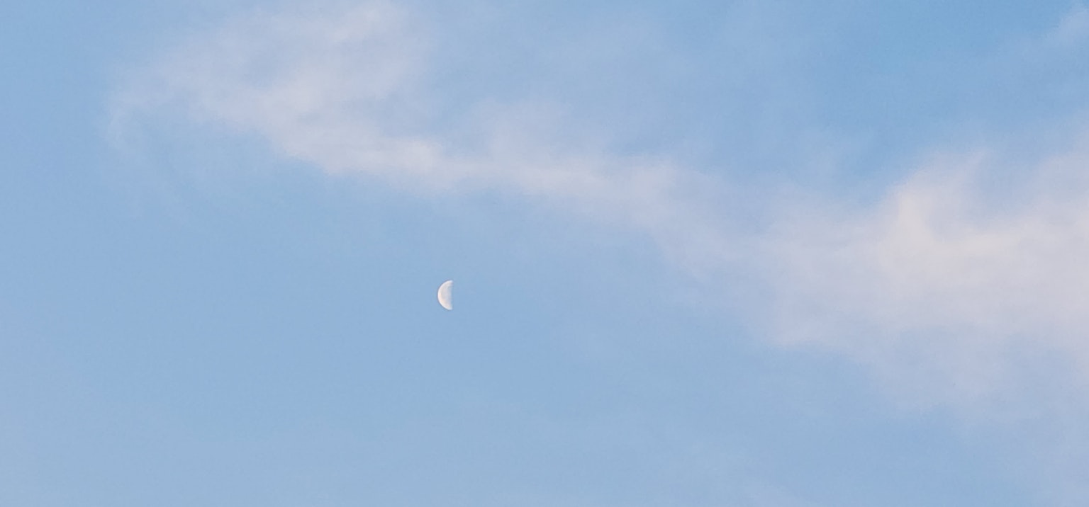 藍天中的白月亮和淡淡的雲