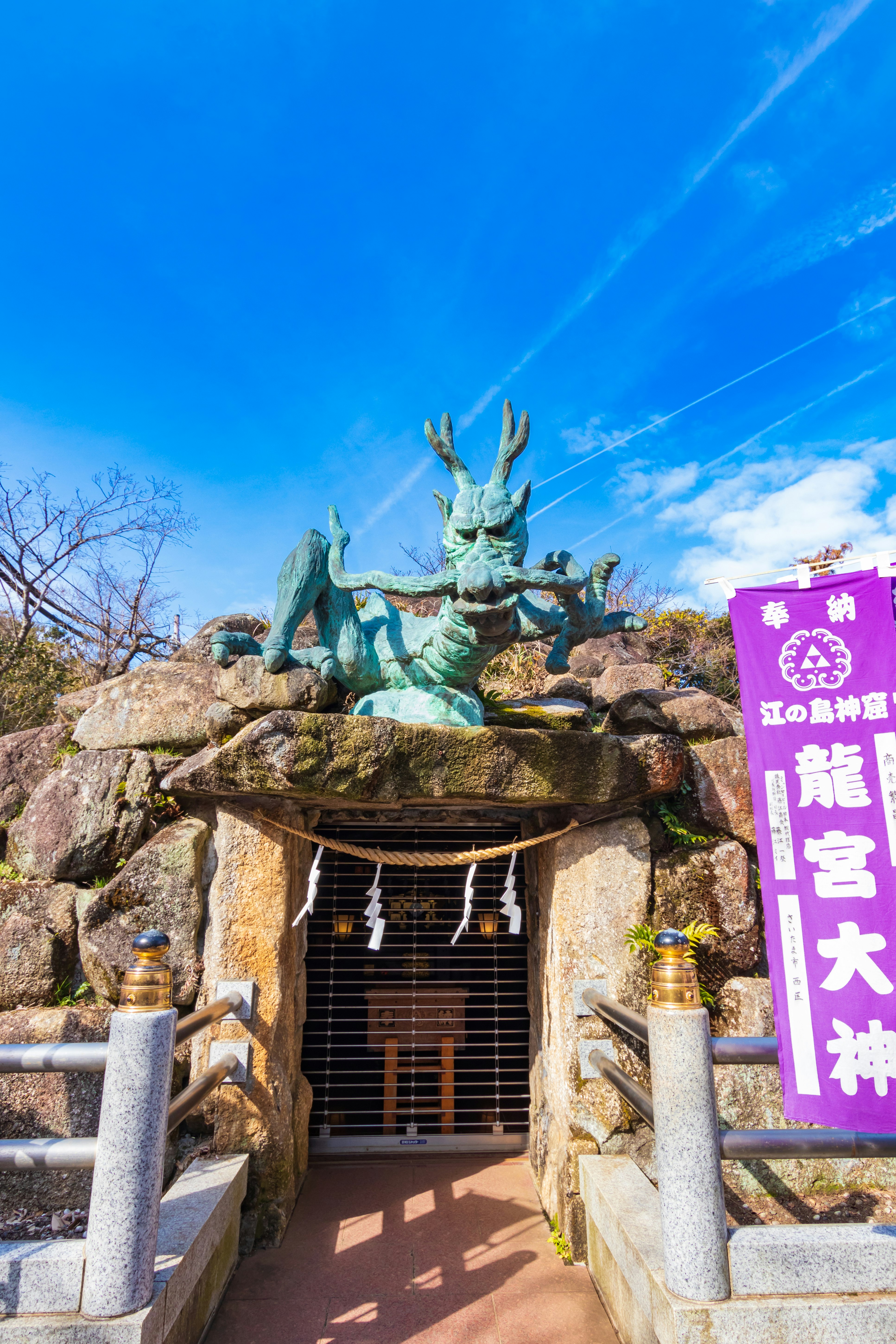 龍宮大社の石段と青空の狛犬像のある参道