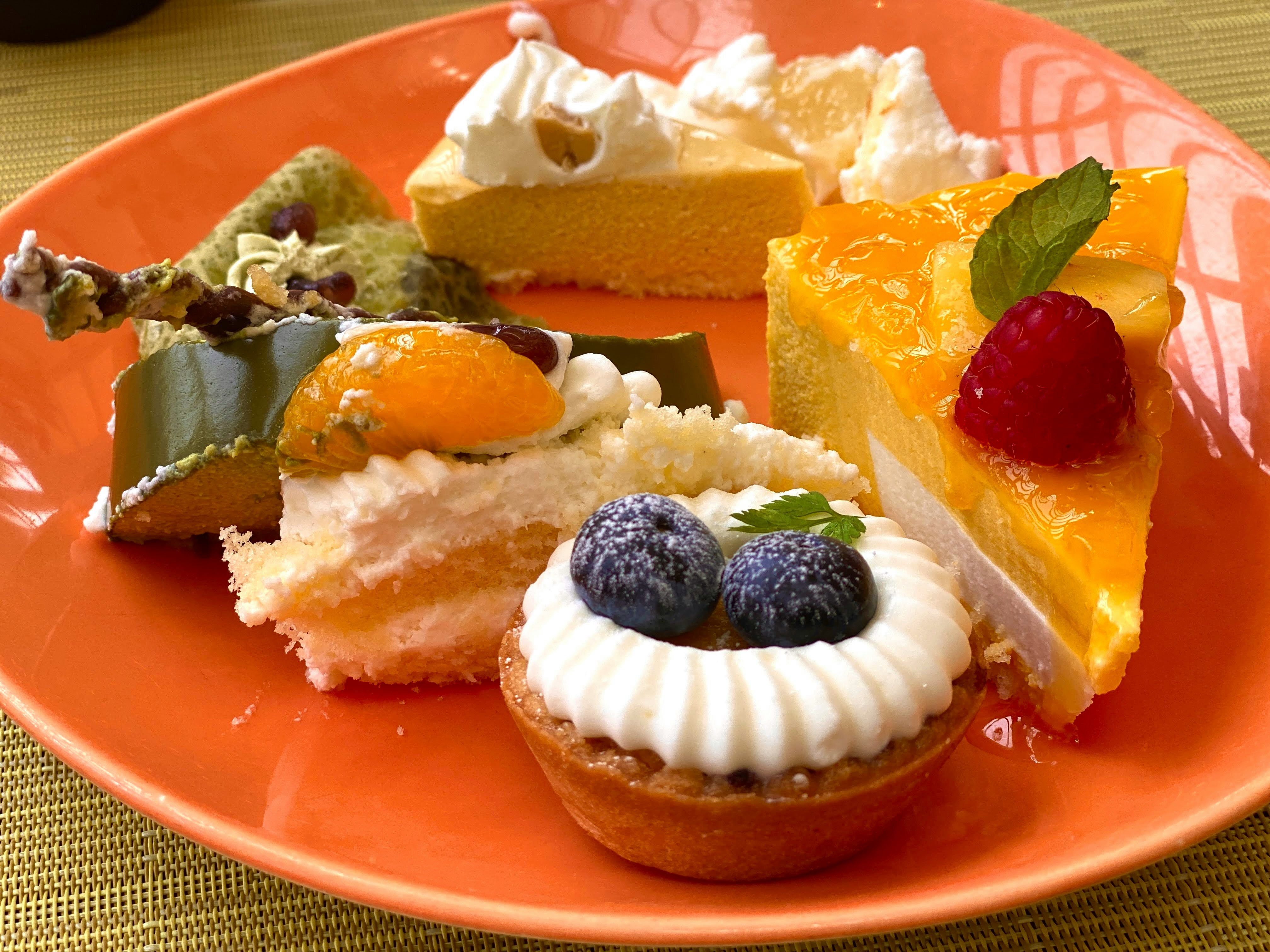 potongan kue berwarna di atas piring oranye