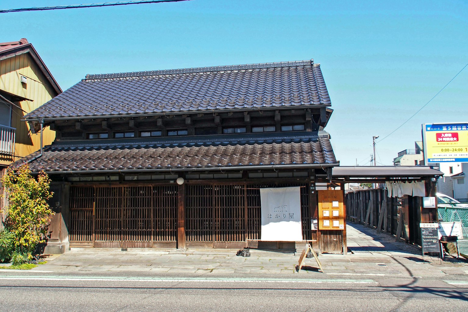 Traditional Japanese house featuring a black tiled roof and wooden exterior
