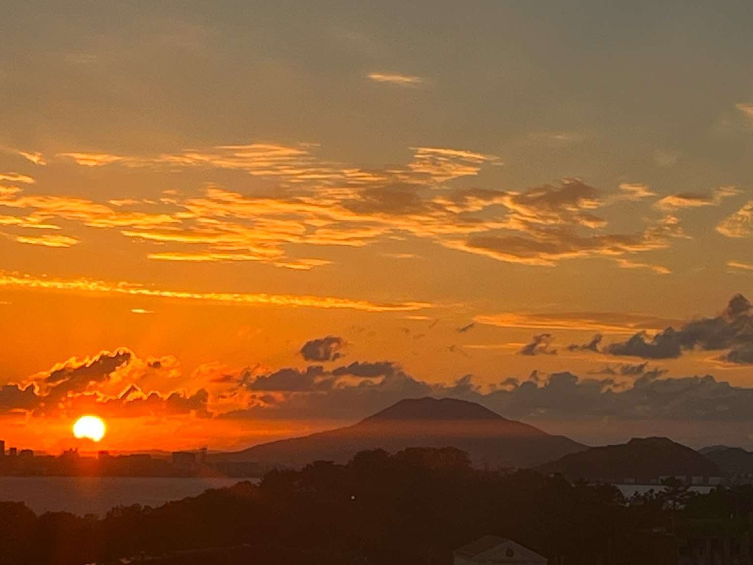 Impresionante atardecer con cielo naranja vibrante y silueta de montaña
