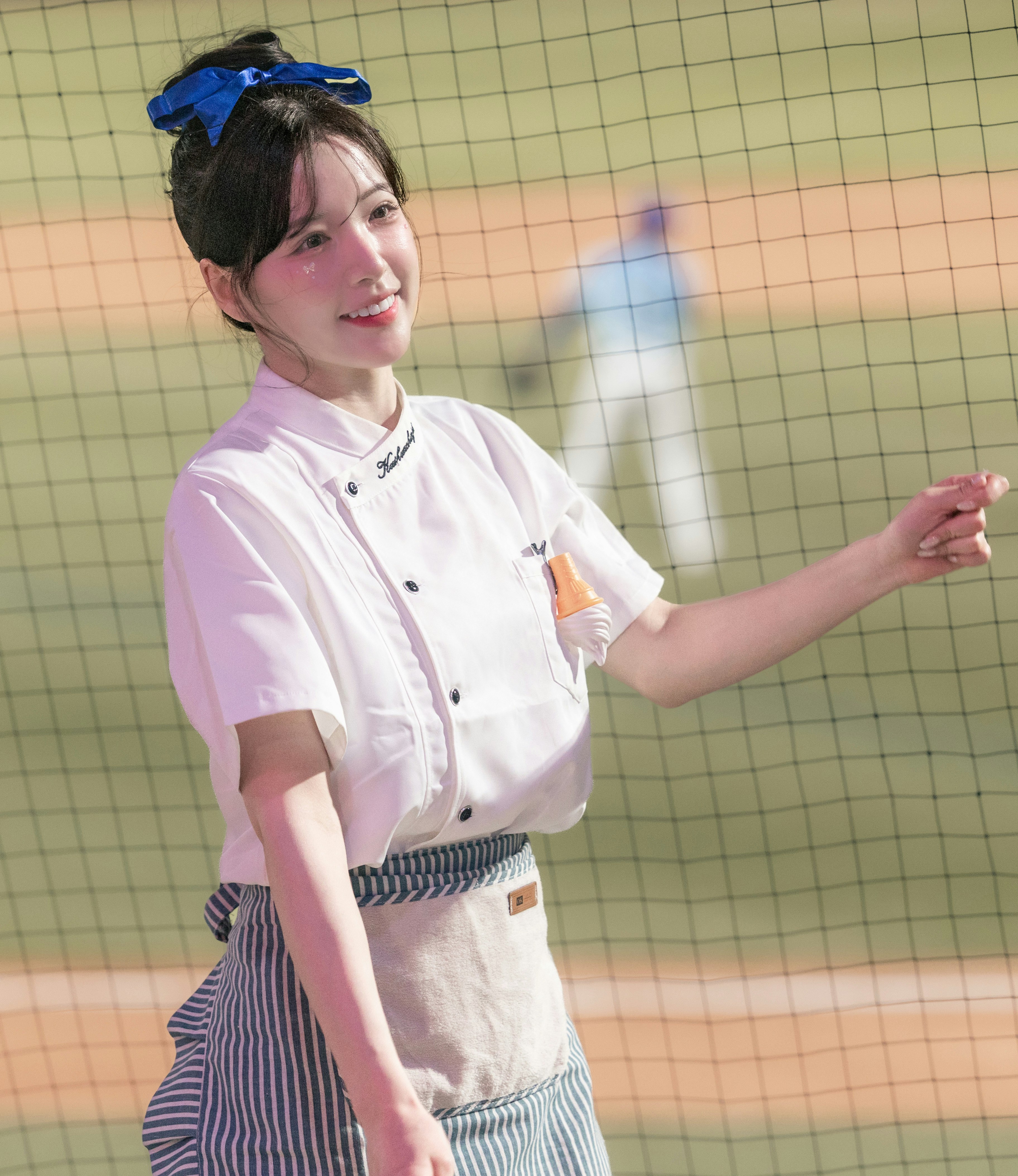 白いコック服の女性がキッチンで手を広げる
