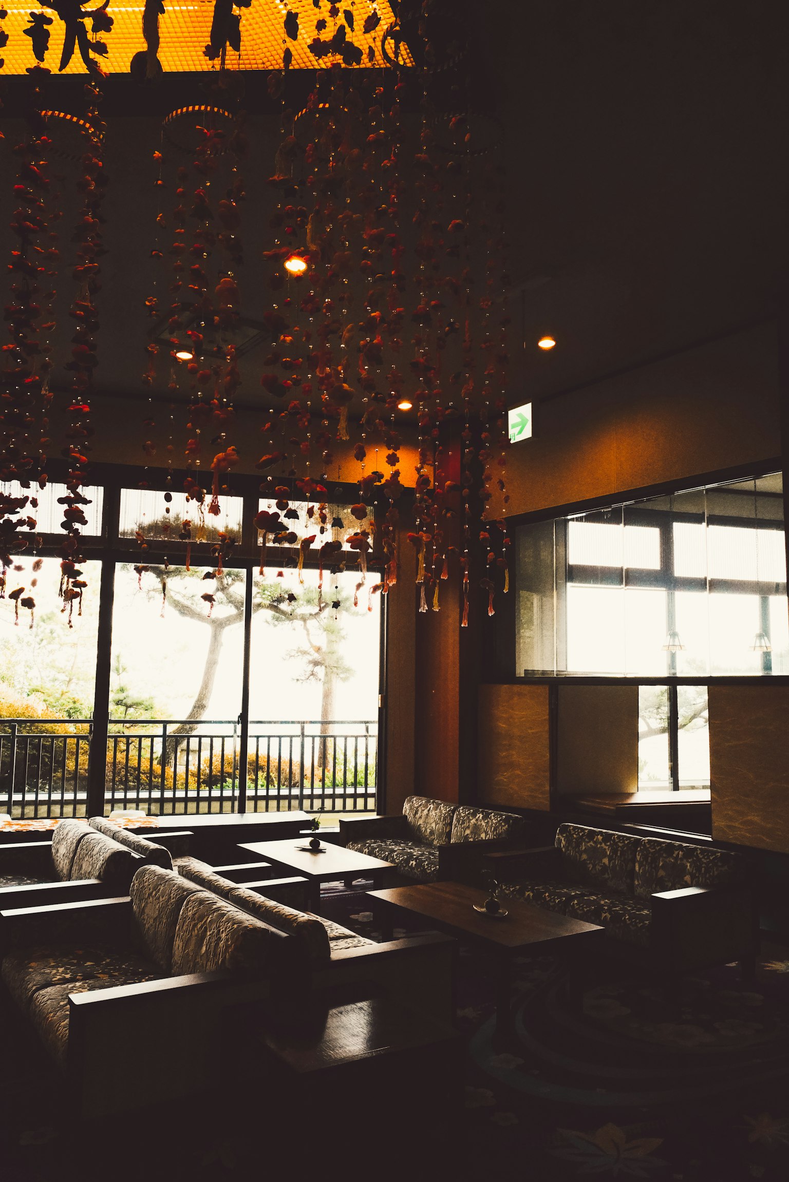 Interior of a cozy cafe featuring large windows and decorative chandelier