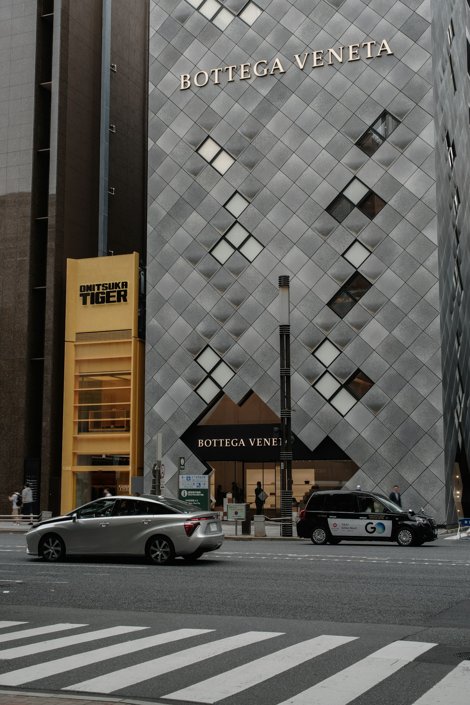 Street view featuring Bottega Veneta store with modern architecture and passing cars