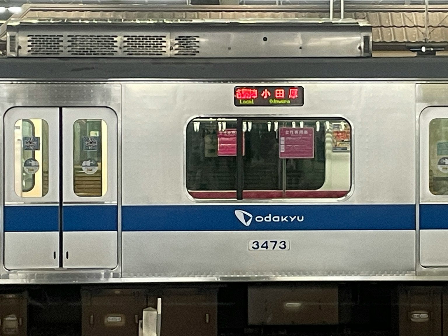 Tàu Odakyu màu bạc với sọc xanh và số xe 5473 hiển thị