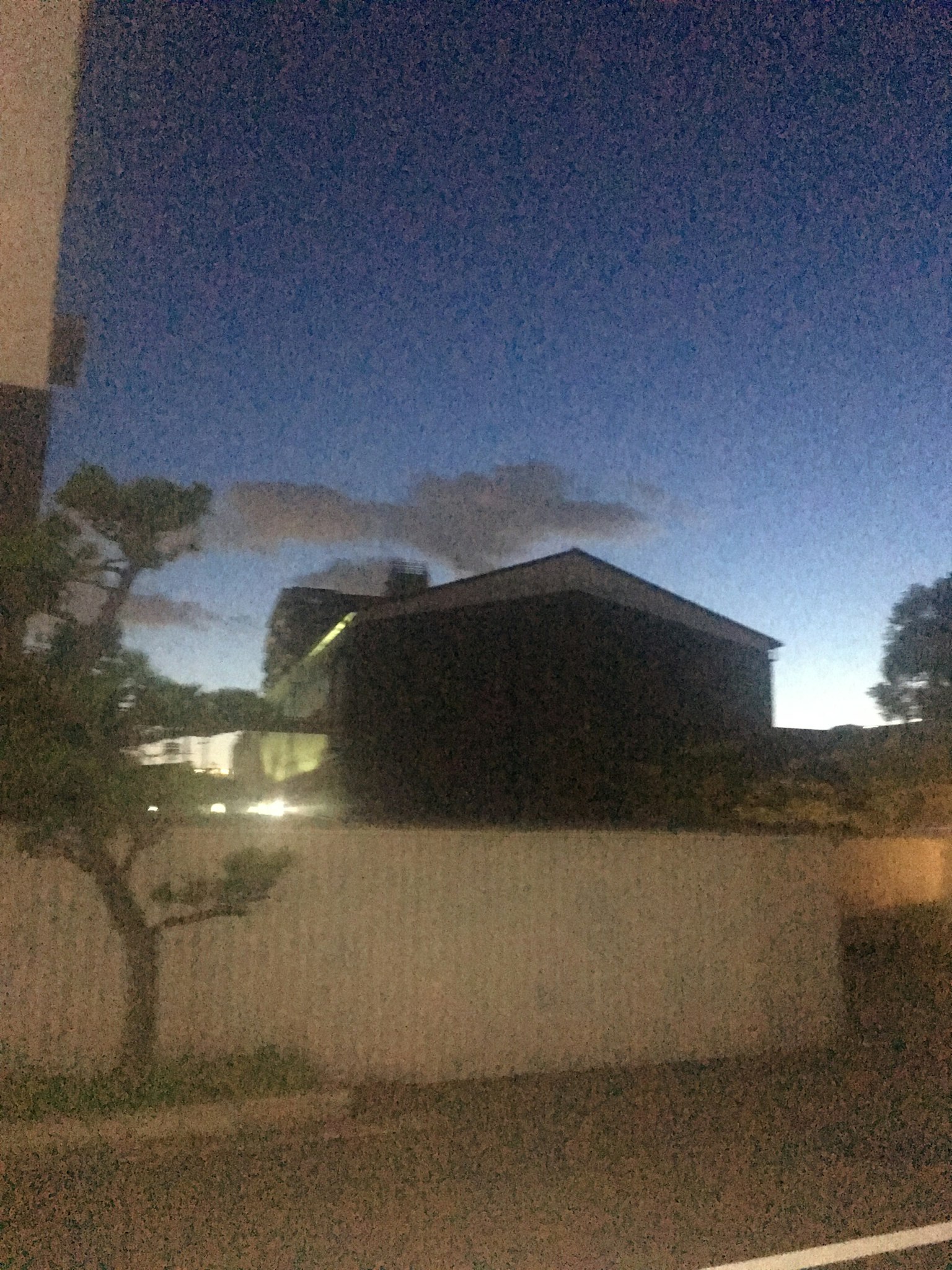 Ein schwarzes Haus unter einem schwachen Dämmerungshimmel mit Wolken
