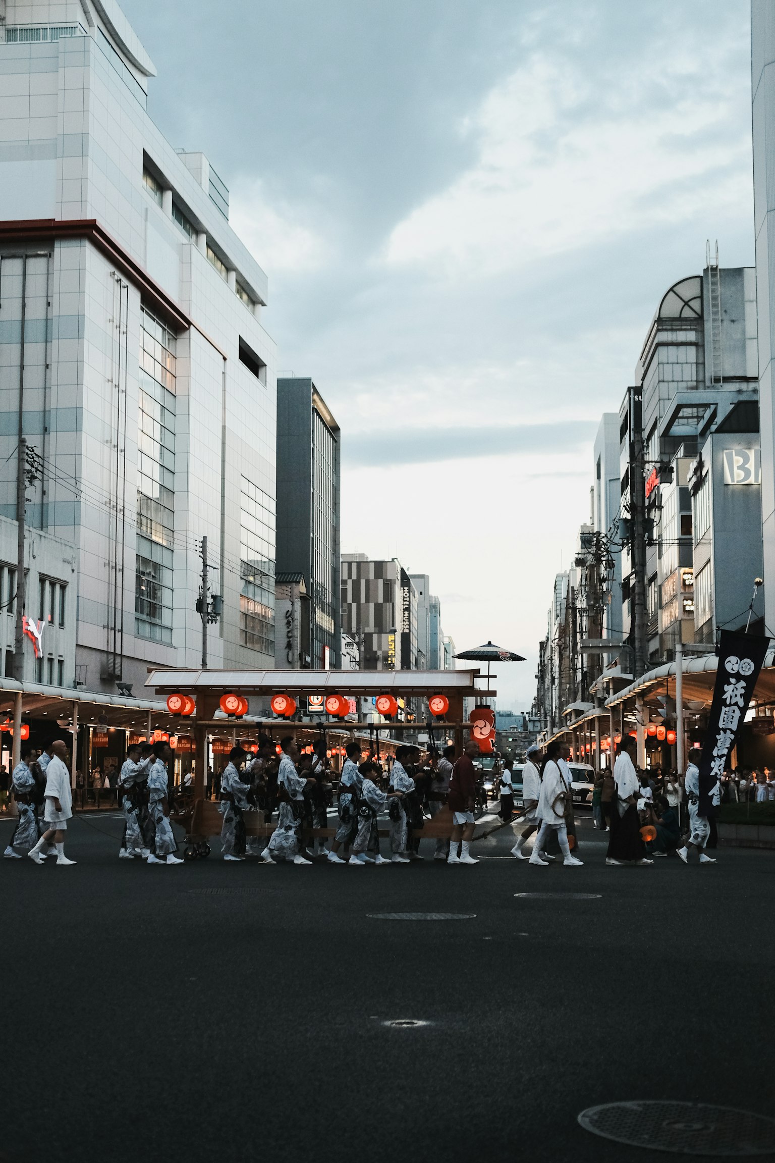 Crowd crossing a busy street with modern buildings
