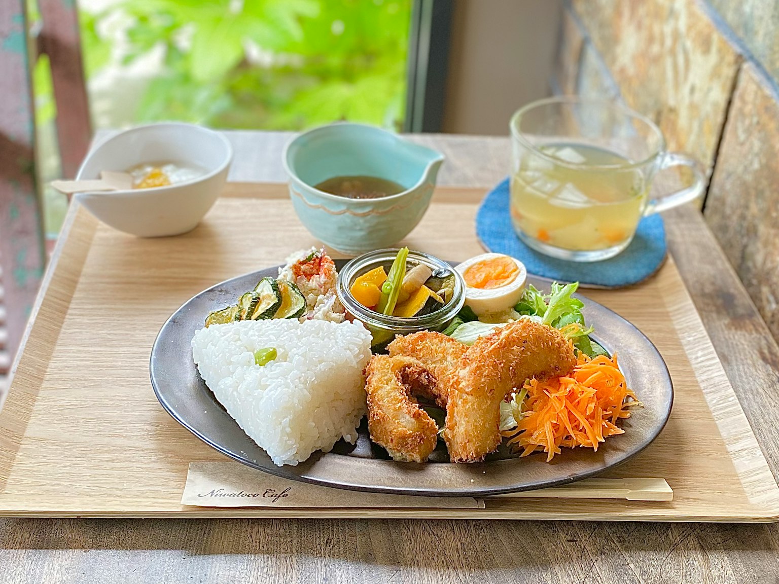 A delicious Japanese meal plate featuring fried items, salad, and white rice