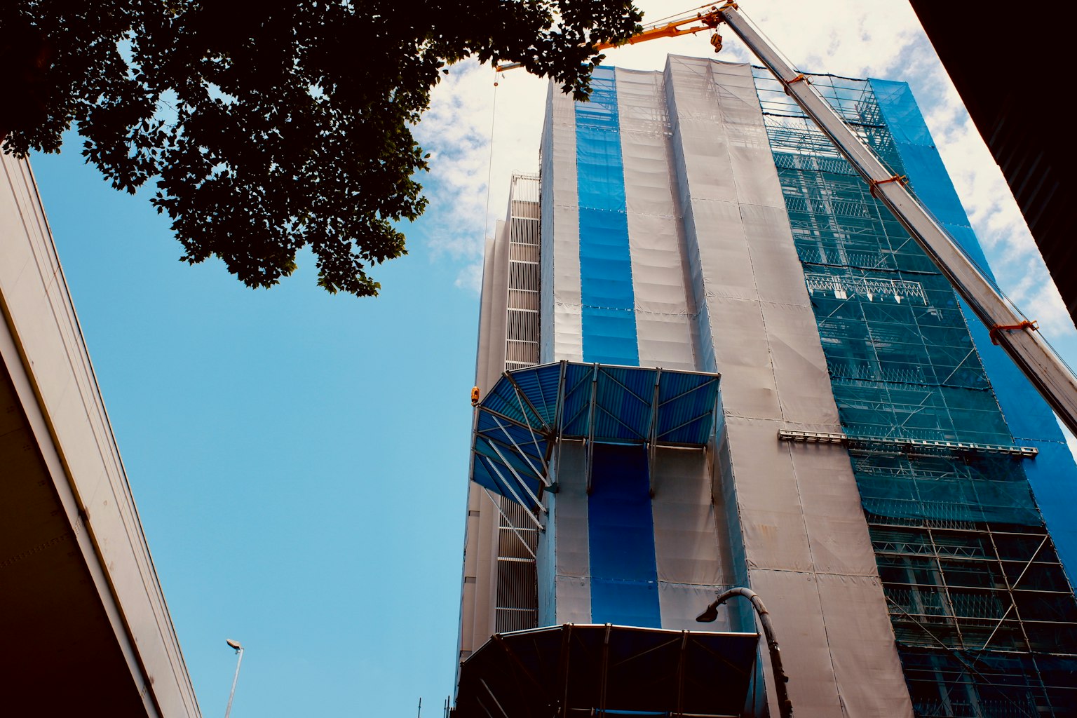 Construction of a high-rise building with blue glass facade