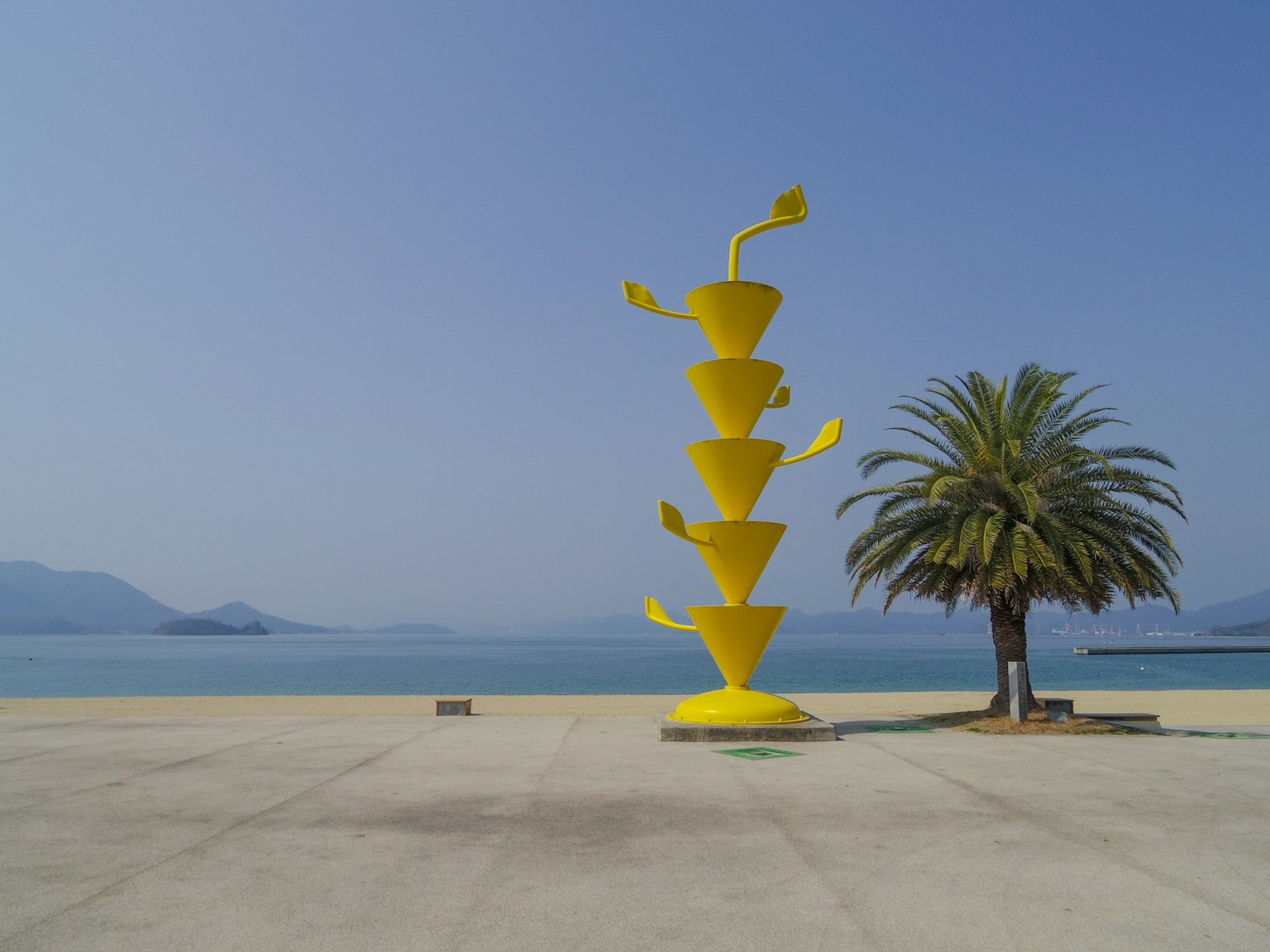 海边的生动黄色雕塑和棕榈树